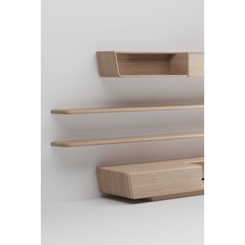 The LATUS Modular System by Artisan features minimalist wooden shelves mounted on a white wall, crafted from solid wood with natural oils and wax. Its design includes three long, flat surfaces and two small box-like compartments in light wood for a sleek, modern look.