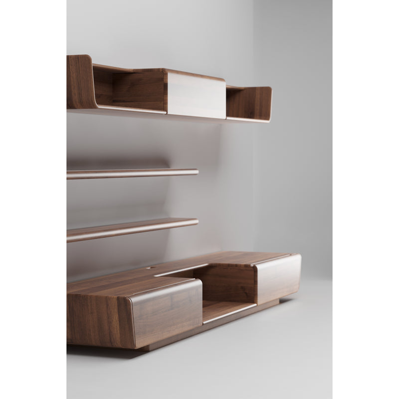 The LATUS Modular System by Artisan is a minimalist wooden shelf crafted from solid wood, featuring three floating levels on a light gray wall. The bottom shelf has two large rectangular compartments with rounded edges, all finished with natural oils and wax for a sleek look.