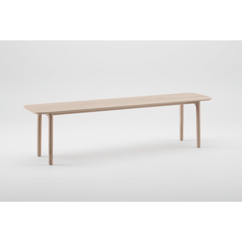 The NEVA Bench by Artisan features a simple, rectangular wooden design with four cylindrical legs against a plain white backdrop. Crafted using CNC carving techniques, it boasts a smooth, light wood finish and rounded edges that highlight its organic forms.