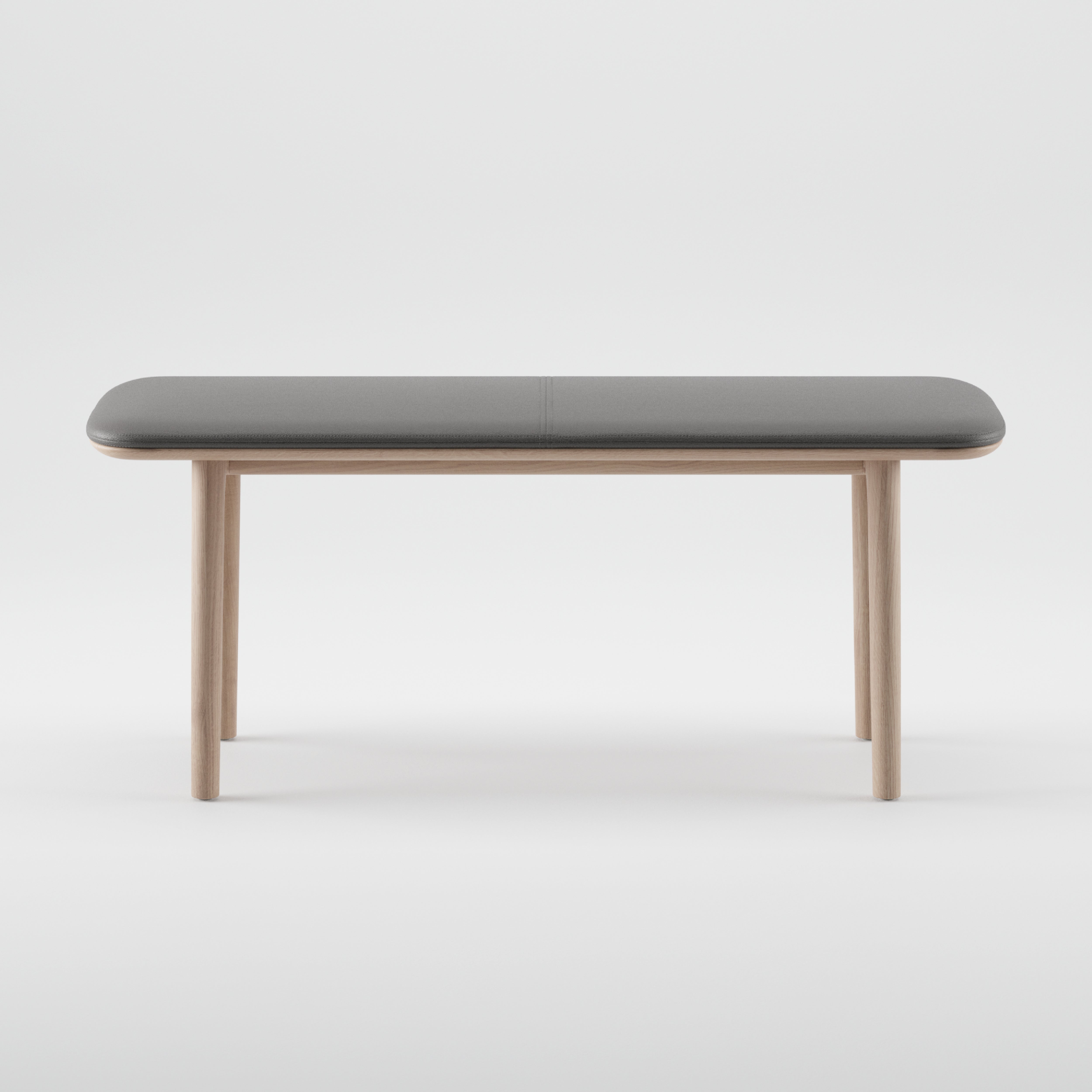 The Artisan NEVA Bench from the Neva collection boasts a minimalist design with a sleek rectangular gray top and light wooden legs, crafted using organic wood forms. It effortlessly blends modern and natural elements against a plain white backdrop.
