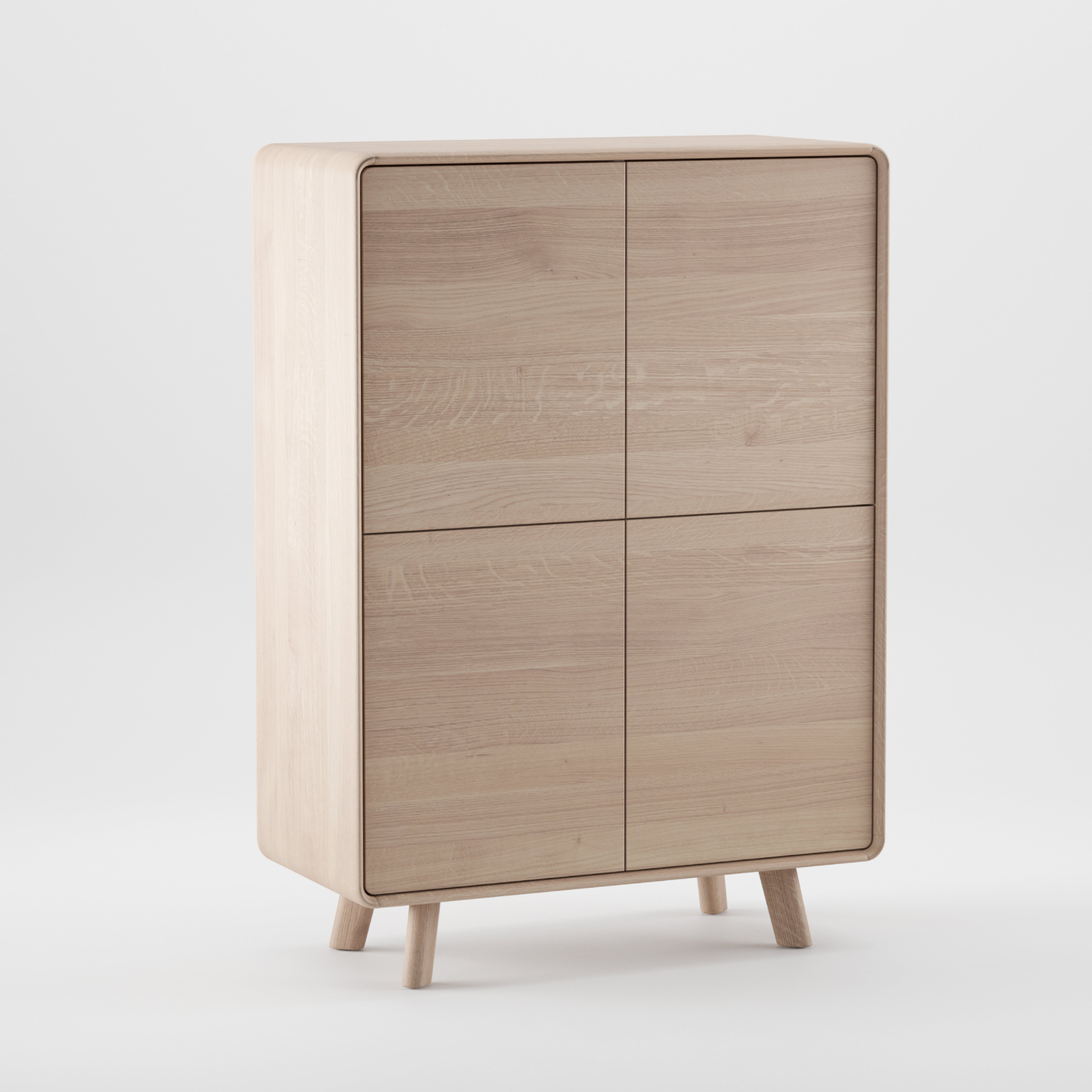 The NEVA Highboard by Artisan is a light wooden cabinet with two doors and a minimalist design, featuring natural finishes and smooth edges. Handcrafted, it stands on four short legs against a plain white background.