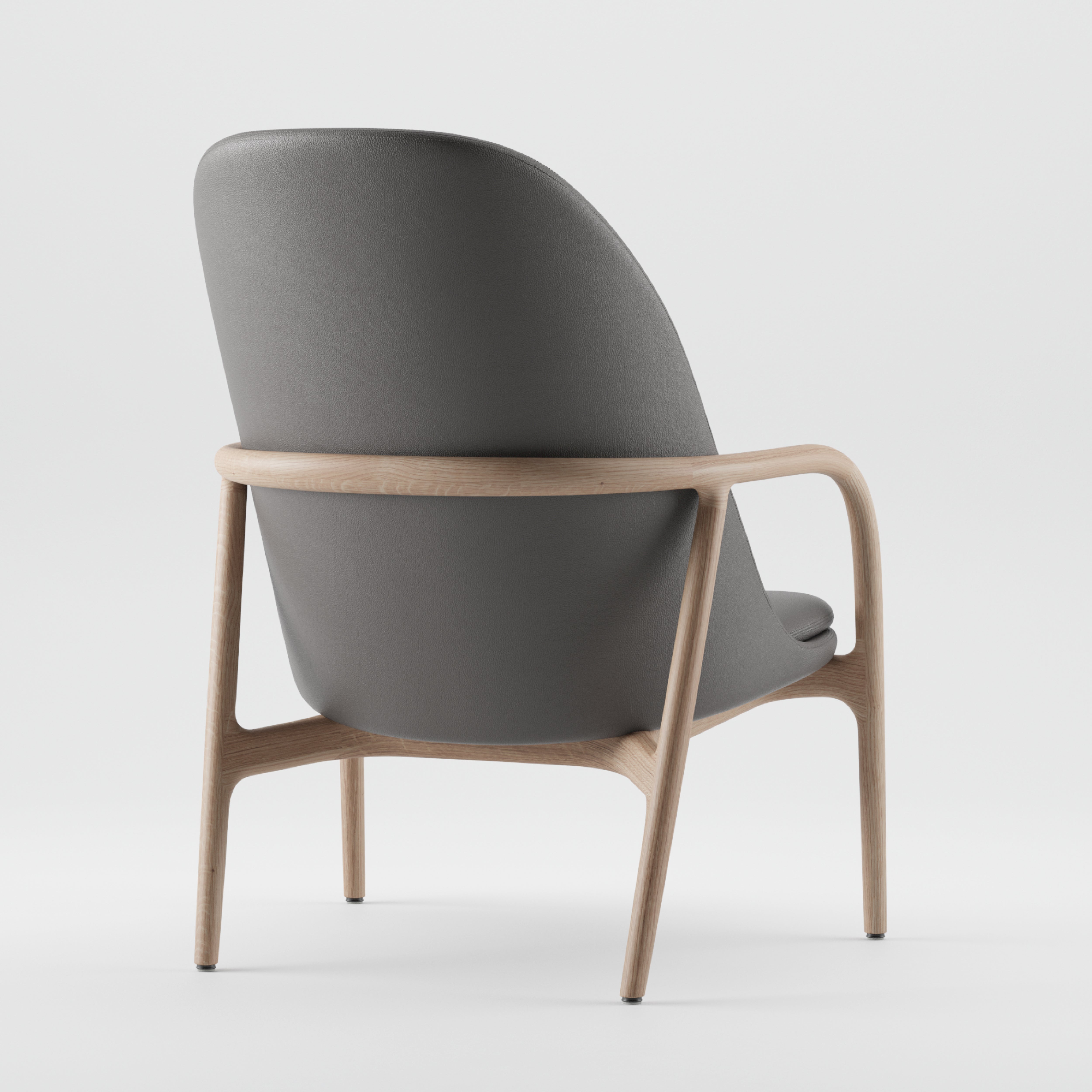 Introducing the NEVA Lounge Chair High by Artisan: a modern masterpiece with a sleek, minimalist design. This Scandinavian artisanal chair features a wooden frame and curved backrest upholstered in dark gray fabric, offering an elegant contrast against a white background.