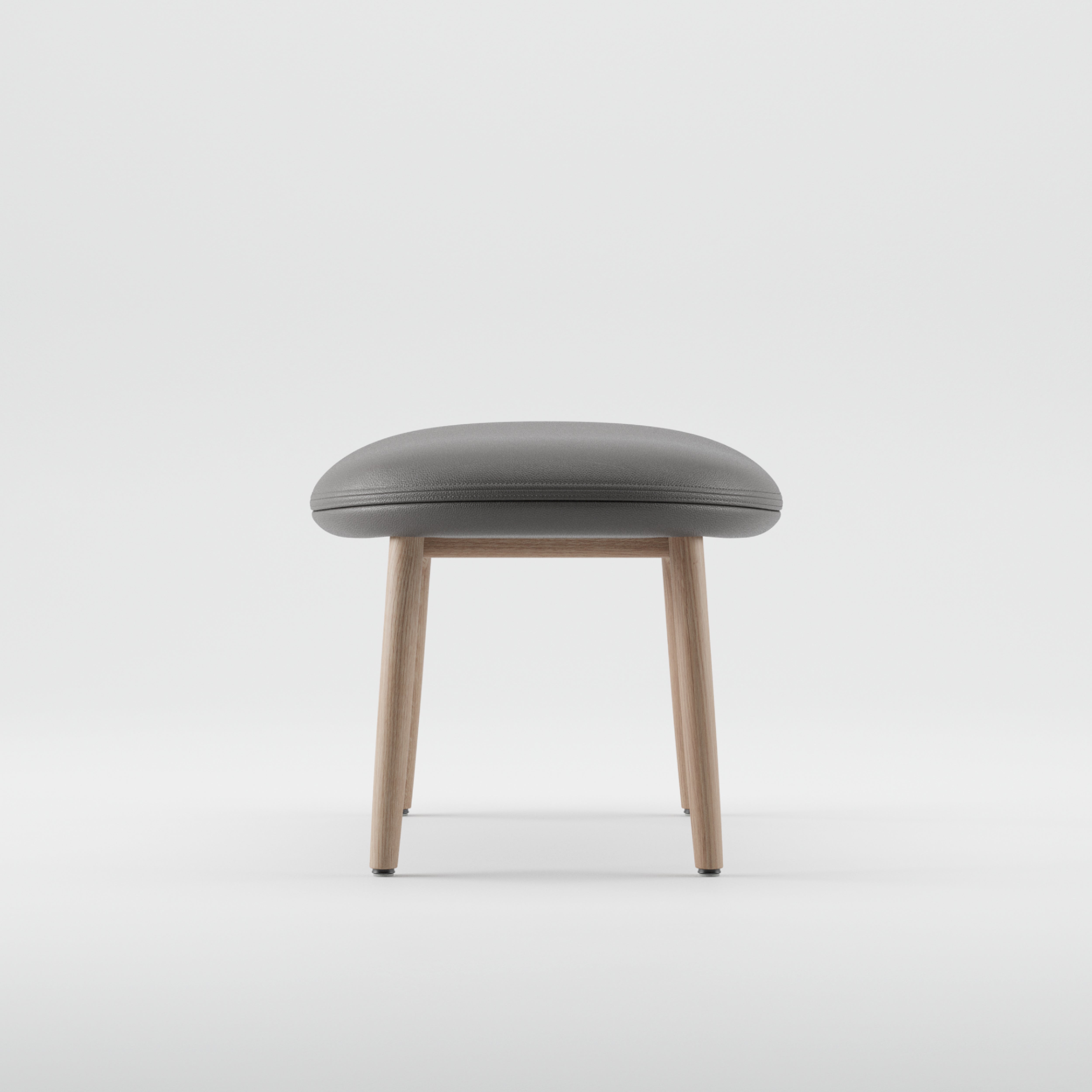 The NEVA Ottoman by Artisan, featuring a grey cushioned seat and light wooden legs, elegantly embodies modern Scandinavian lounge design against a stark white background.