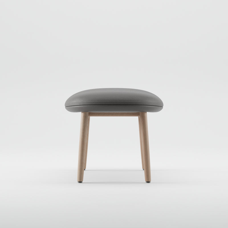 The NEVA Ottoman by Artisan, featuring a grey cushioned seat and light wooden legs, elegantly embodies modern Scandinavian lounge design against a stark white background.