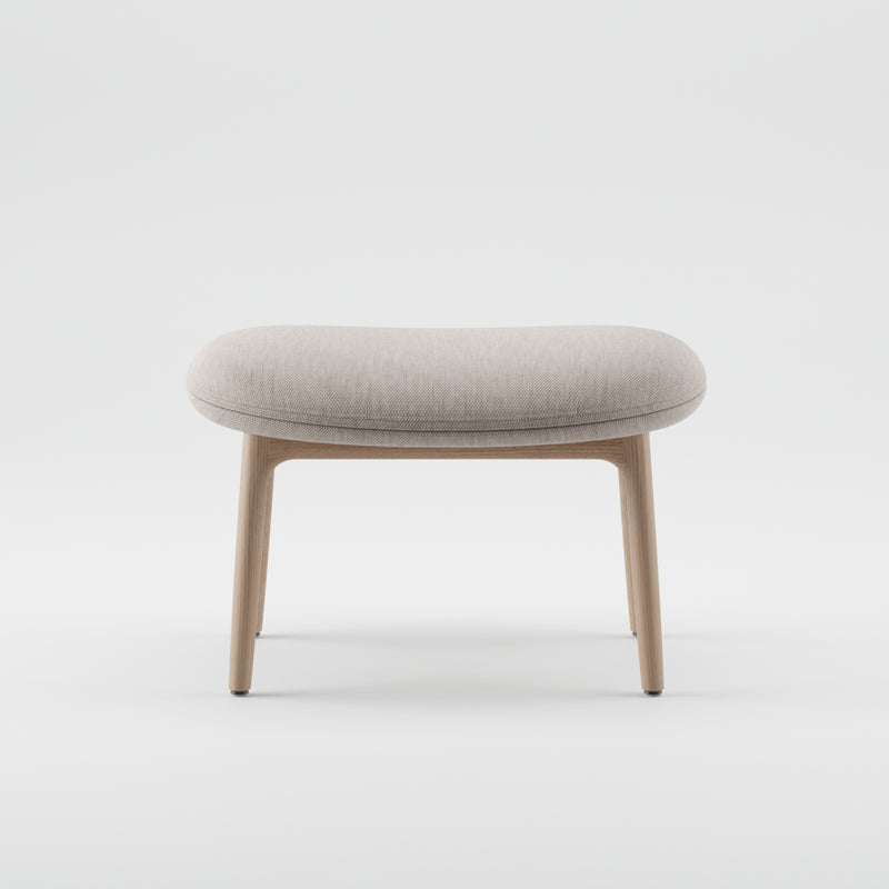 The NEVA Ottoman by Artisan features a light gray cushioned seat and wooden legs, embodying modern Scandinavian design. Its minimalist style highlights clean lines and simplicity on a plain white background, crafted to perfection through CNC carving for added precision.