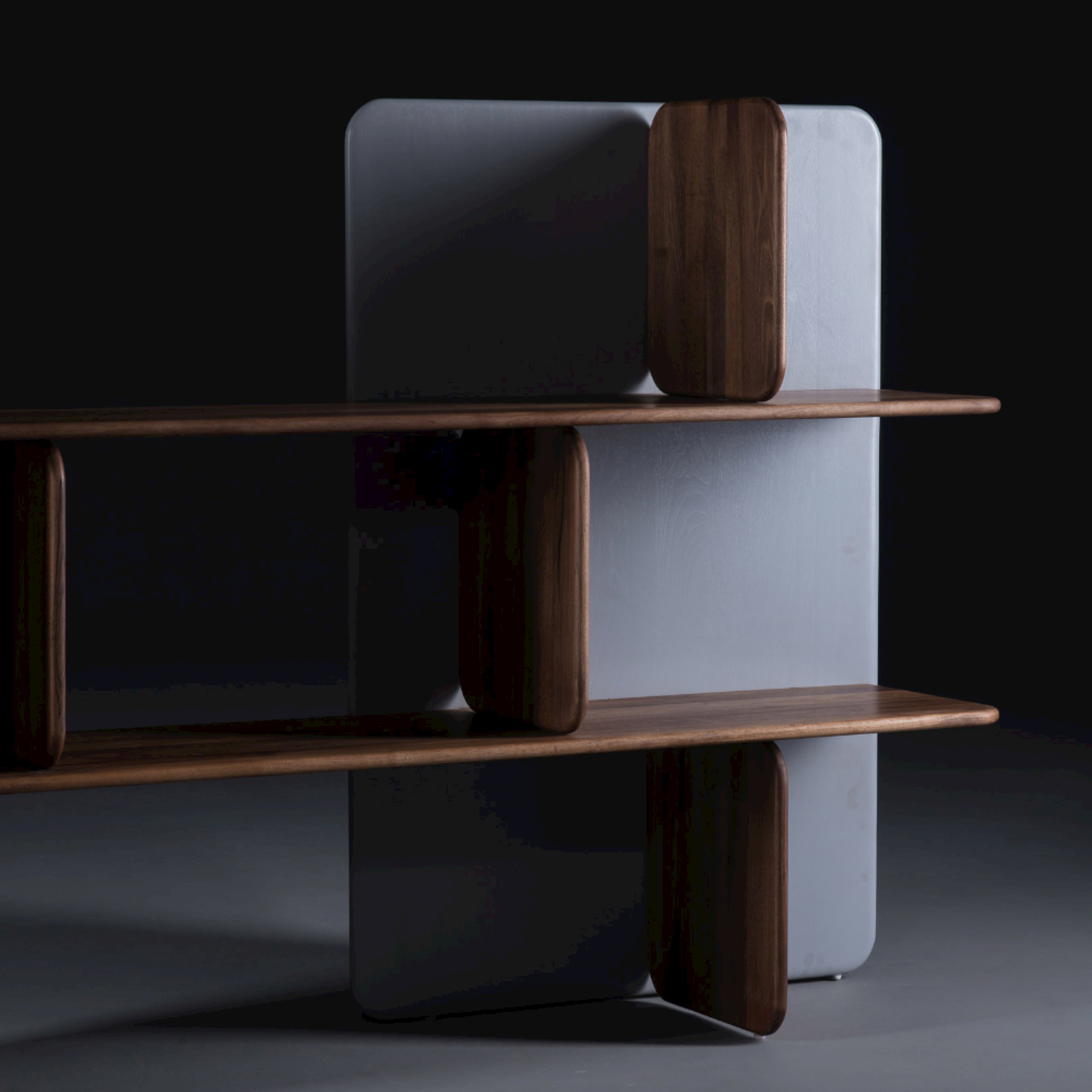 The SOFT Shelf by Artisan is a modern wooden shelving unit made from solid wood. It features three levels with rounded edges and vertical dividers, enhanced by a dark gradient background that highlights its smooth texture, contemporary design, and eco-friendly materials with natural finishes.