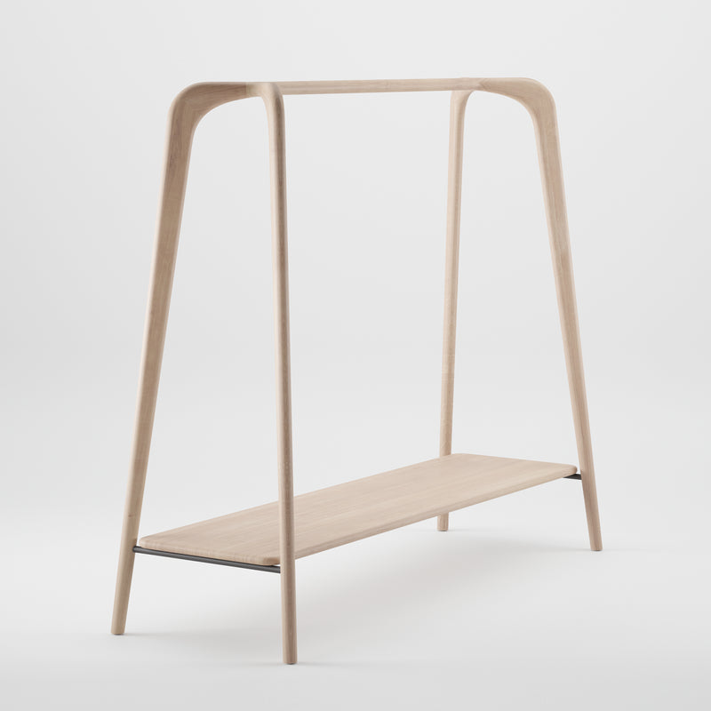 The SWING Coat Stand by Artisan features a luxurious wood texture, smooth finish, two slanted legs, and a horizontal rod. Below is a narrow storage shelf. Crafted from eco-friendly materials, its simple and elegant design stands out against a white background.