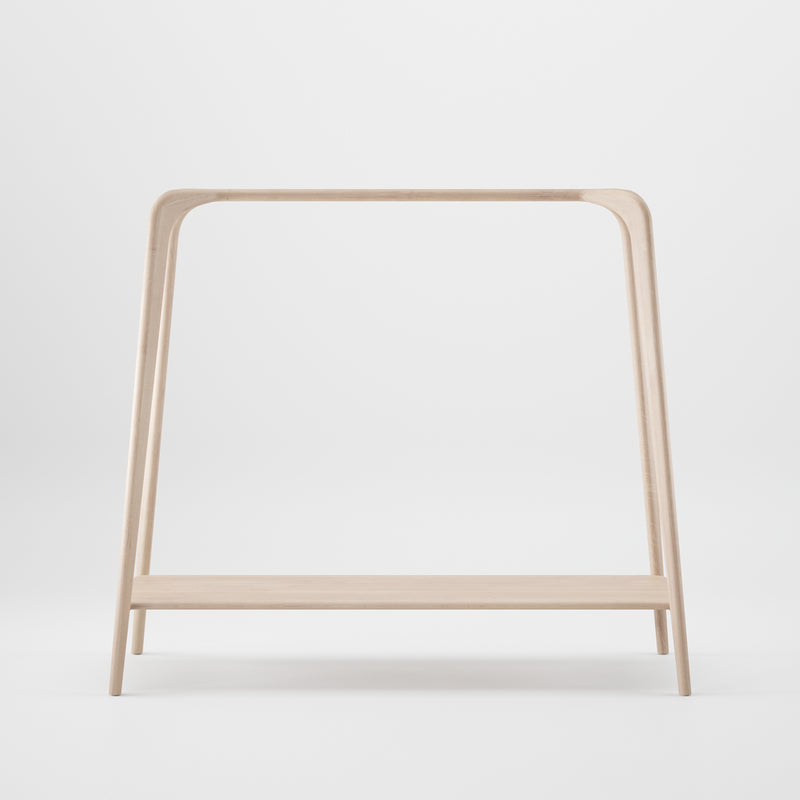 The SWING Coat Stand by Artisan is a minimalist wooden clothing rack with an A-frame design. Crafted from solid wood, it features a single horizontal beam for hanging clothes and a flat shelf for storage, all set against a plain white background.