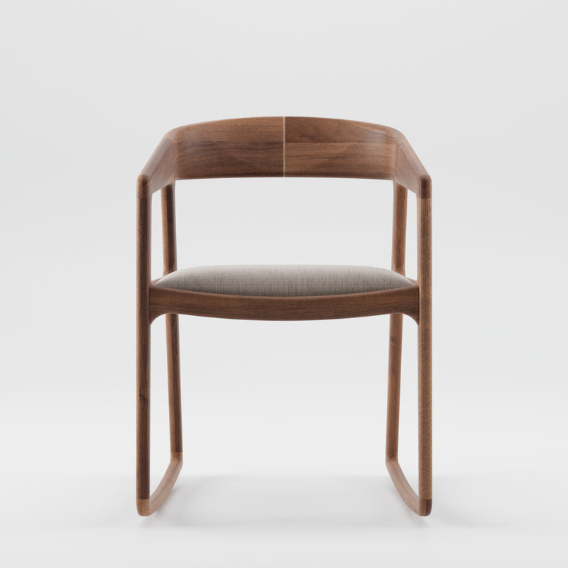 The TESA SWING CHAIR by Artisan is a minimalist piece featuring solid wood construction, a curved backrest, and a light gray cushioned seat. Finished with natural oils, its smooth, rounded edges boast an eco-friendly modern design against a white background.