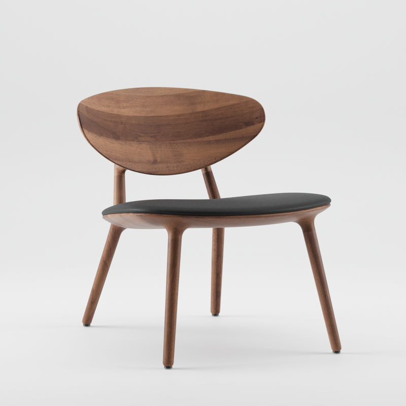The WU Lounge Chair by Artisan is a wooden chair with a modern minimalist design, featuring a curved backrest and tapered legs. It has a black cushioned seat and a luxury wood texture with a smooth finish, made from environmentally-friendly materials against a plain white background.