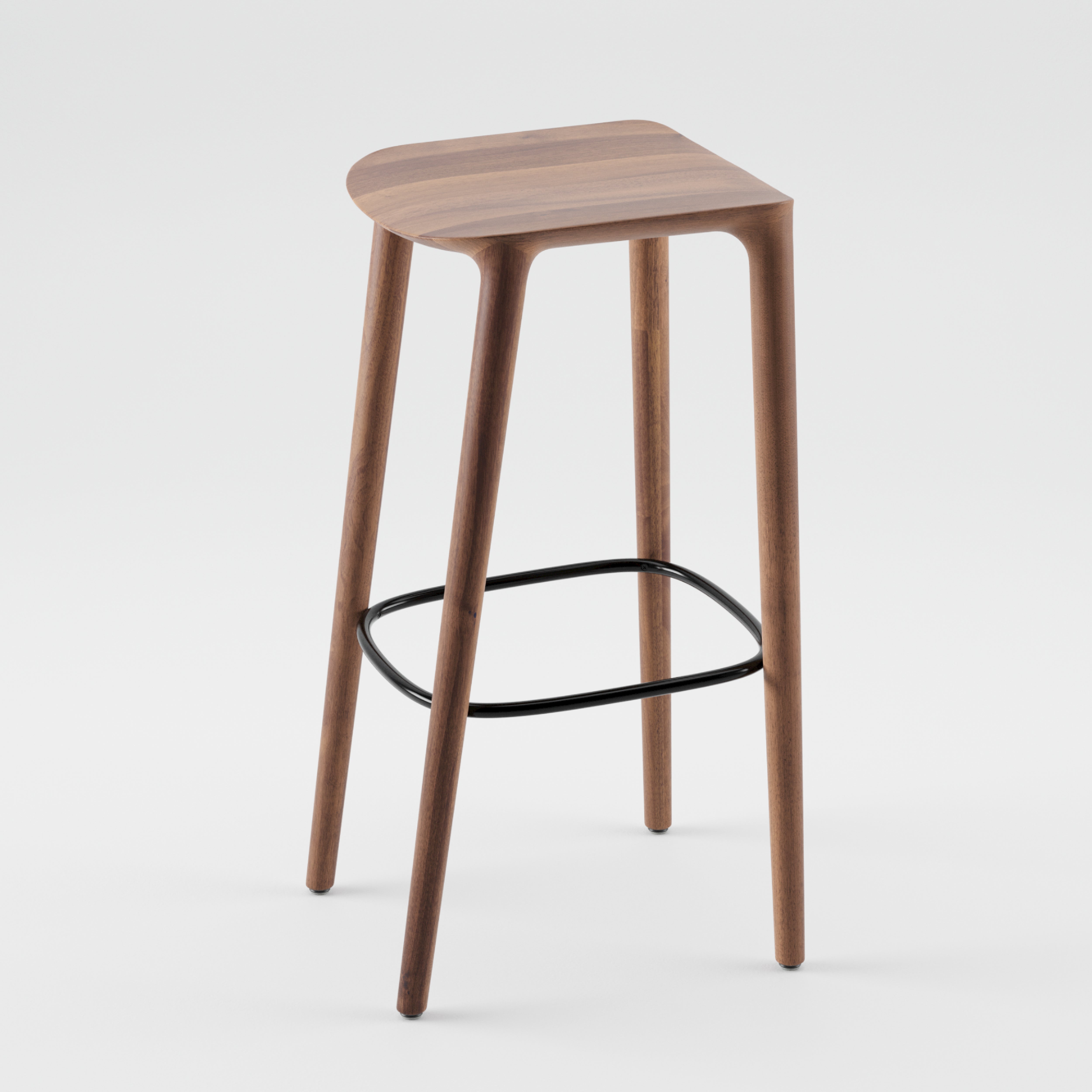 The Artisan NEVA barstool, part of the Neva collection, boasts a minimalist design with four tapered wooden legs and a black metal footrest. Its elegantly curved seat features precise CNC carving and a smooth finish for a sleek, contemporary look.