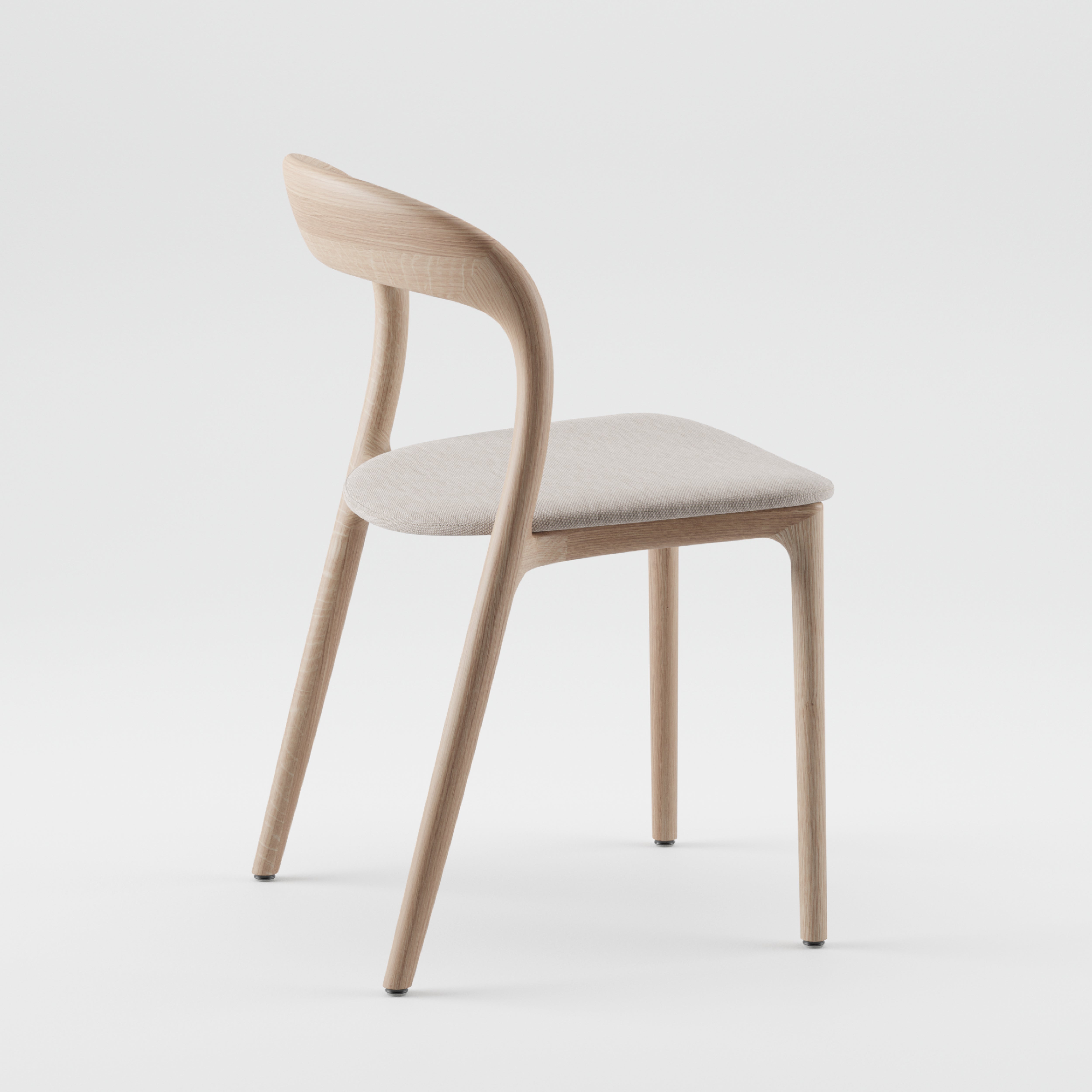 The NEVA light chair by Artisan features a modern design with a smoothly curved backrest and a light beige cushion. Set against a light background, its slender legs highlight its contemporary elegance, showcasing the artisanal craftsmanship of the Neva collection.