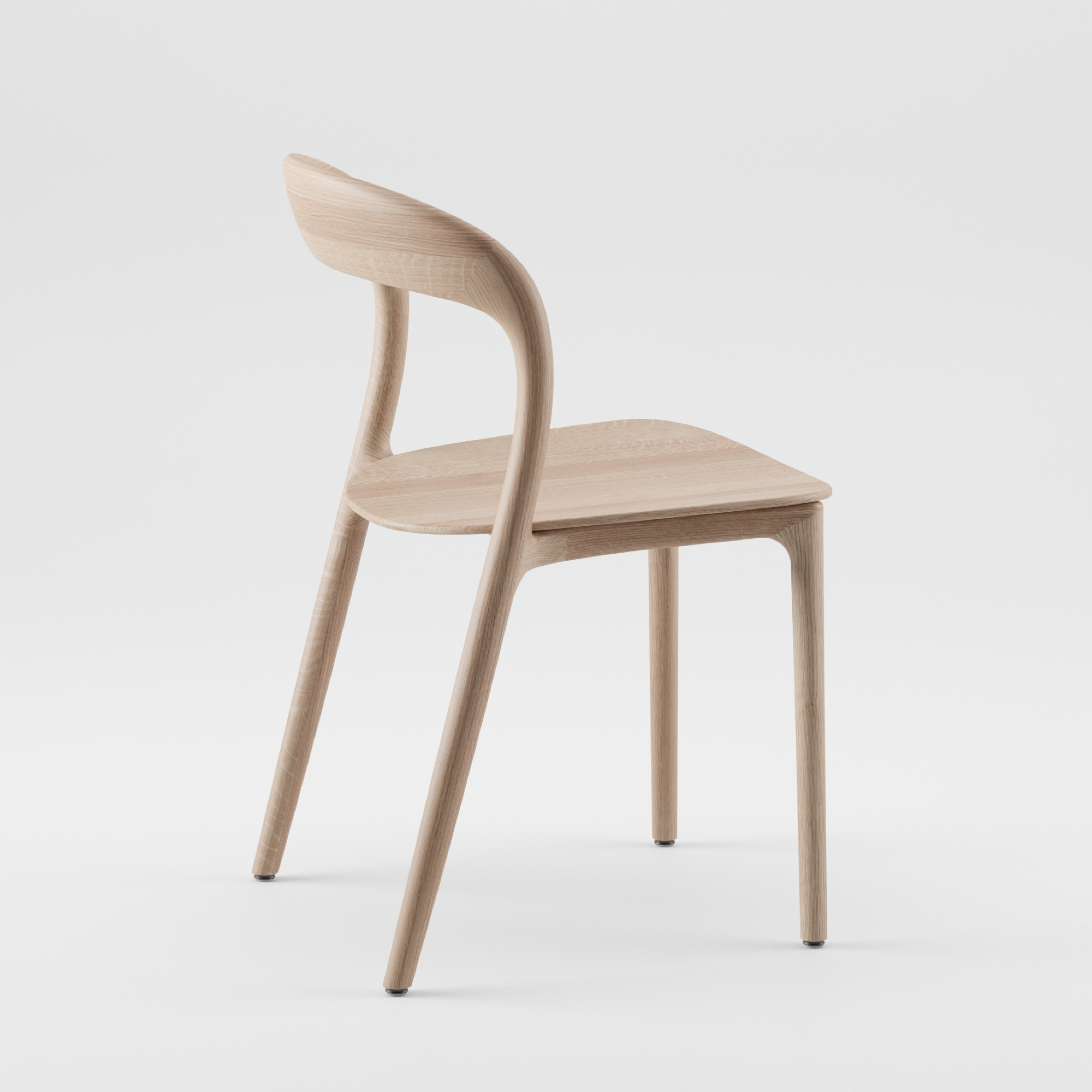 The NEVA light chair by Artisan is a minimalist wooden piece from the Neva collection, featuring a smooth, curved backrest and seat with CNC carving. It stands on four slender legs of light-colored wood, showcasing a sleek, modern design against a plain white background.
