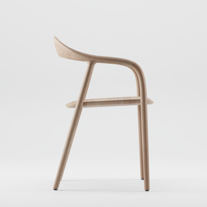 Side view of an Artisan NEVA chair made from American walnut against a plain backdrop, showcasing its sleek, curved design with a smooth finish and slightly angled backrest, highlighting 5-axis CNC precision.