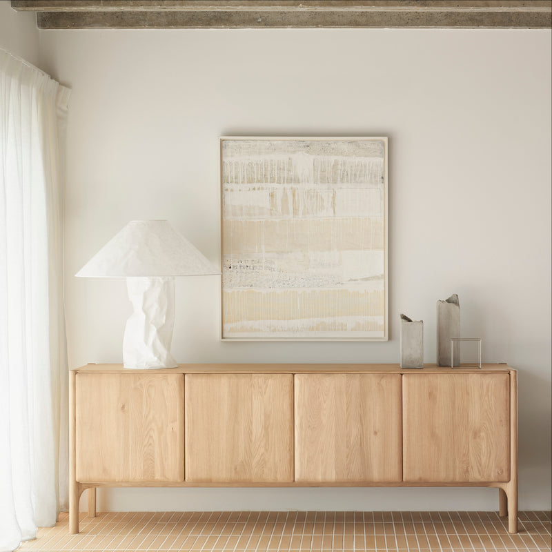 Pi Sideboard in oak with minimalist design, four doors, and smooth finish in a modern living room setting.