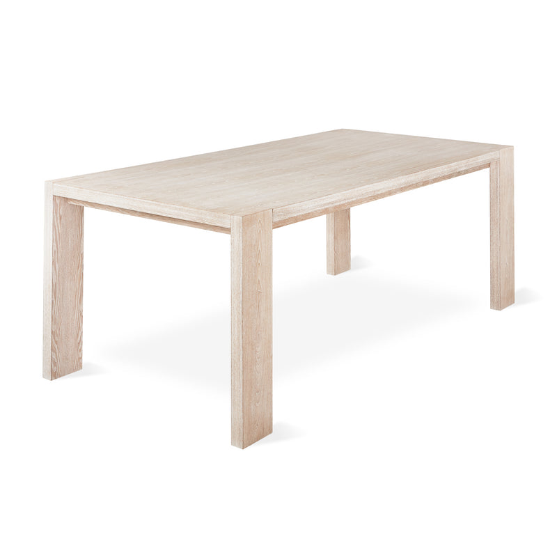 The Gus Modern Plank Dining Table is a rectangular solid wood piece with clean lines and four sturdy legs, featuring a modern design and shown against a white background.