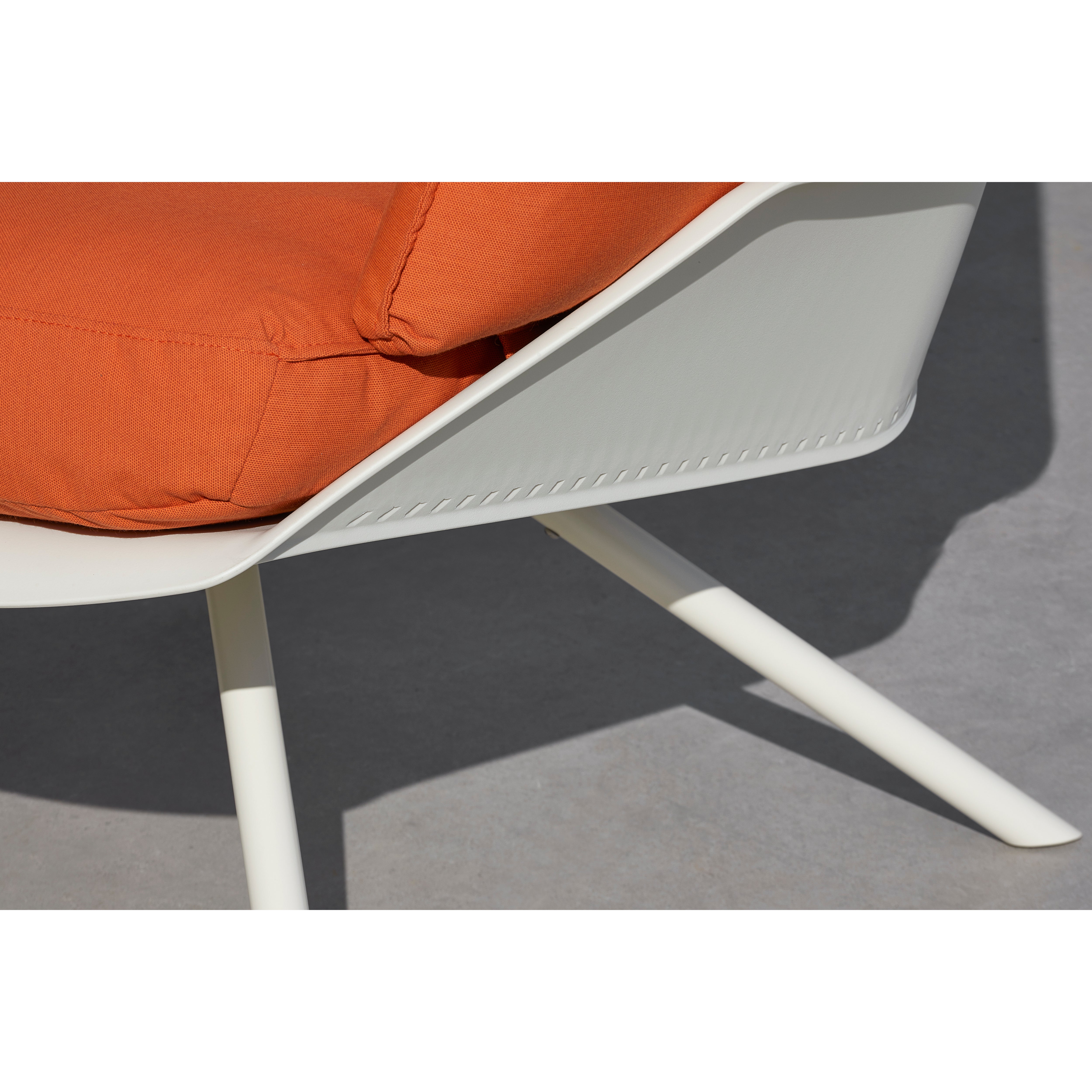 Close-up of the Anou Metal Legs by Resol, featuring a sleek white polypropylene frame and an orange removable cushion. The angled legs and cushion stitching are visible against a concrete floor backdrop.