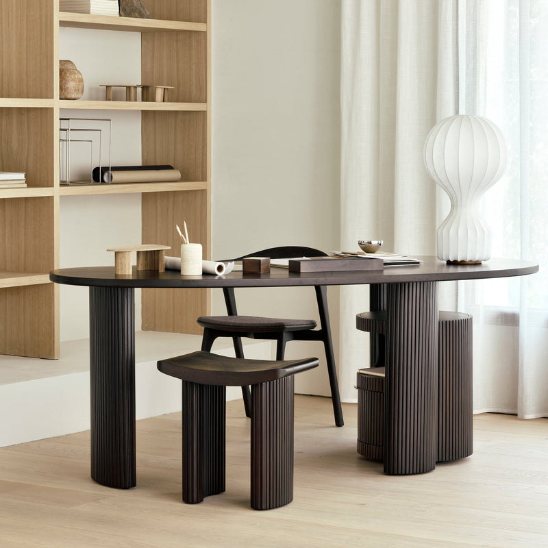 Roller Max Stool in varnished dark brown mahogany with stacked wood-stick design in a modern living space.
