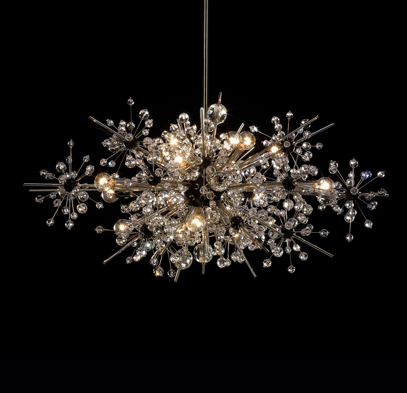 The Metropolitan Chandelier from Lobmeyrs Met Series dazzles with Swarovski crystal orbs and rods radiating from the center like a starburst against a dark background.