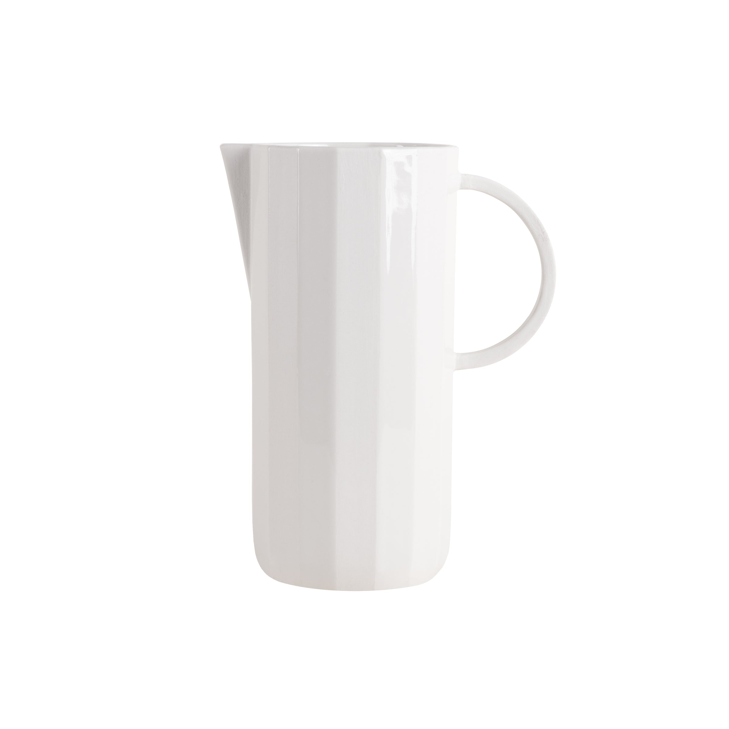 This tall, white ceramic carafe from Schneids Facet Tableware collection features a handle and narrow spout. It has a minimalist design with subtle vertical ridges for texture, set against a plain white backdrop to embody refined color dynamics.