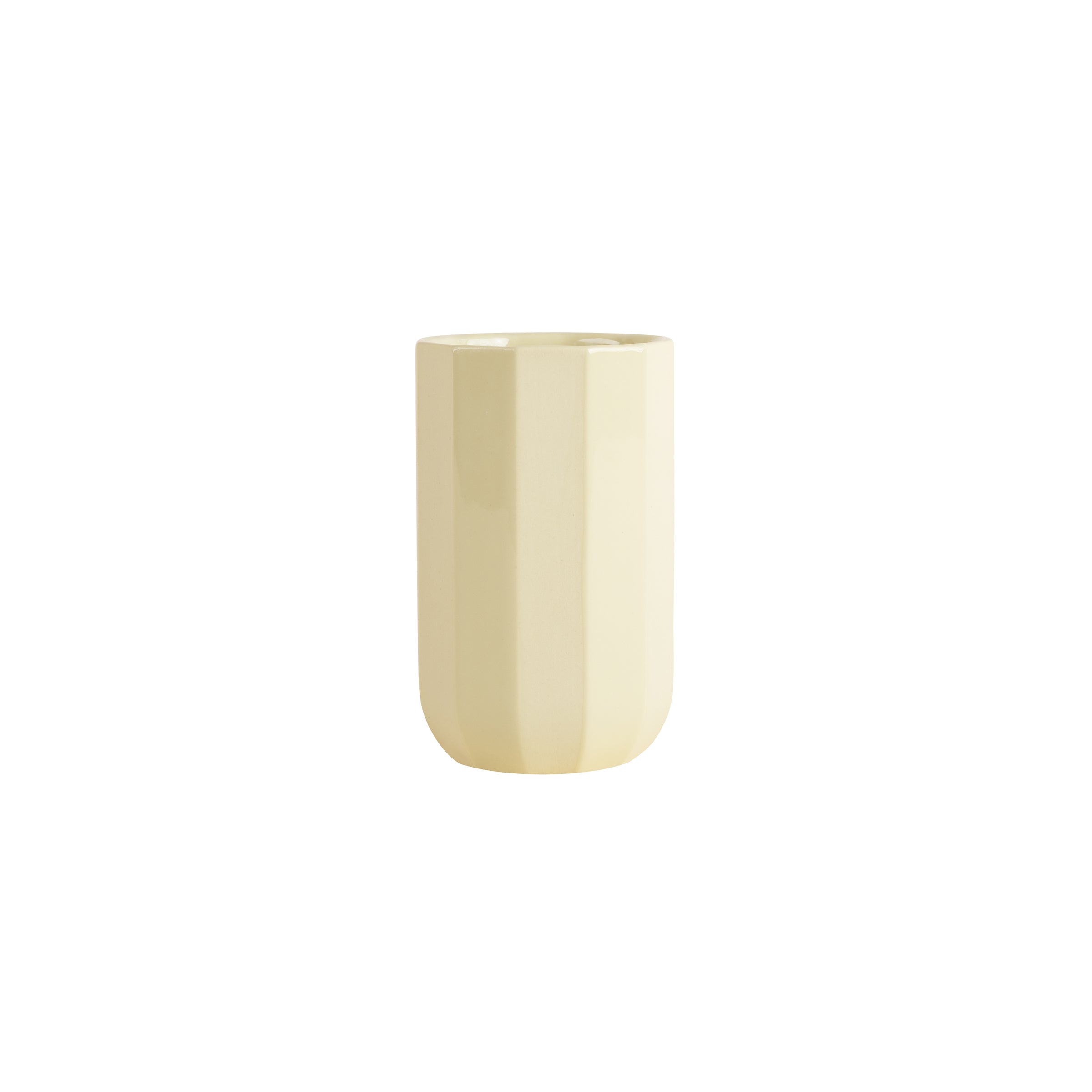 The Facet Tableware Cup by Schneid is a tall, cylindrical, light yellow ceramic piece with a smooth, glossy finish. Its subtle vertical ridges and rounded base add elegance against a plain white background, introducing fascinating color dynamics to any setting.