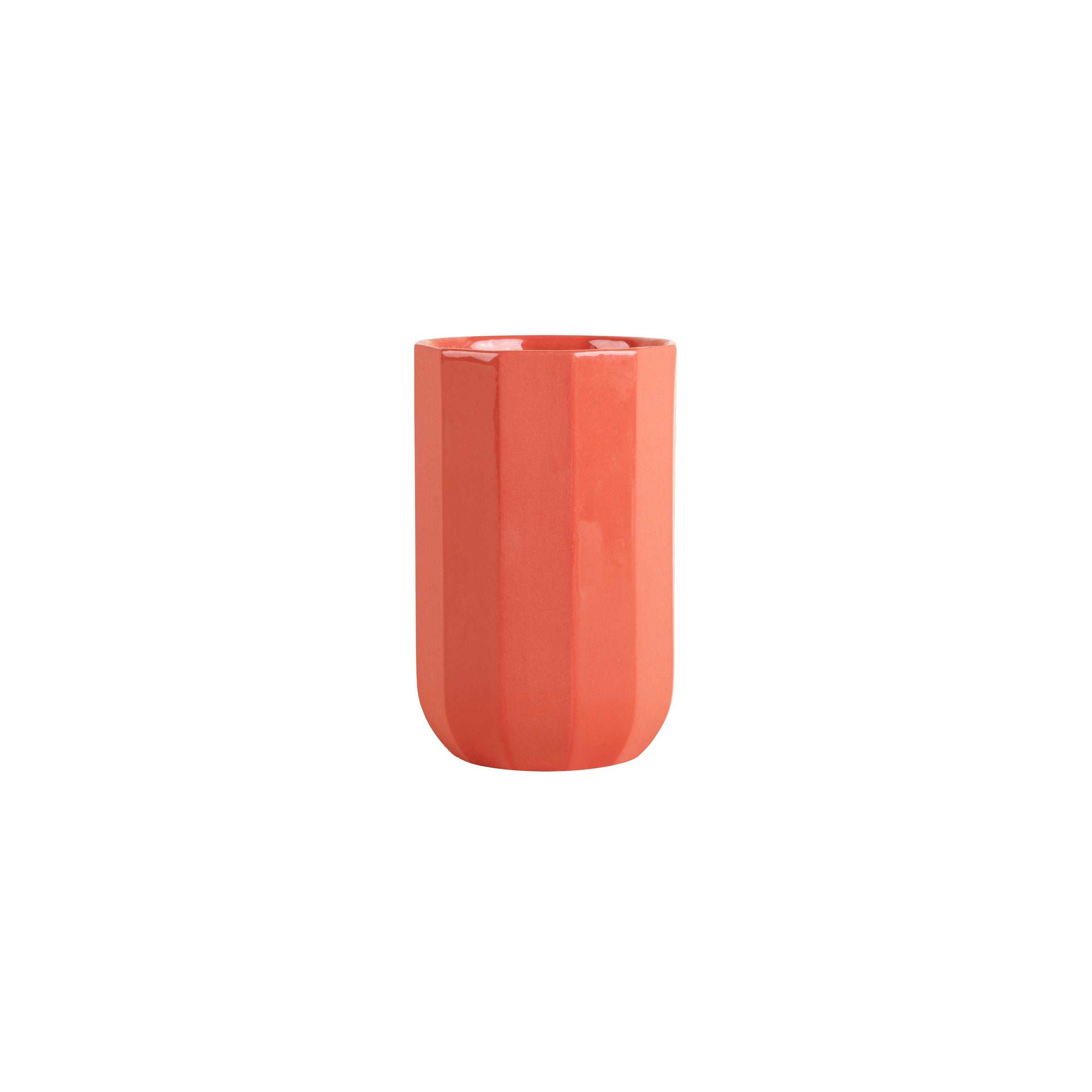 A tall, cylindrical, orange ceramic cup with a textured surface from Schneids Facet Tableware collection stands elegantly against a plain white background, showcasing its vibrant color dynamics.