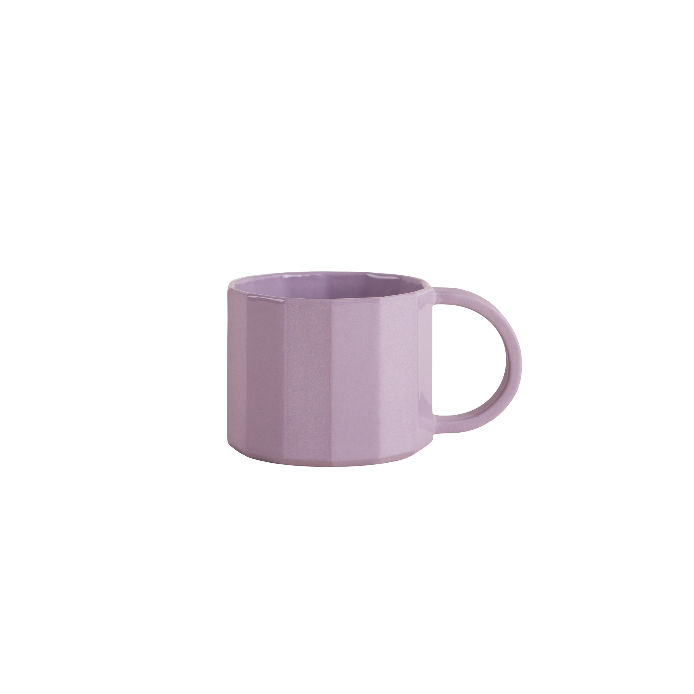 The Schneid Facet Tableware mug is a pastel lavender ceramic piece with a glossy finish, a large handle, and a faceted geometric design. It beautifully showcases subtle color dynamics against a plain white background.