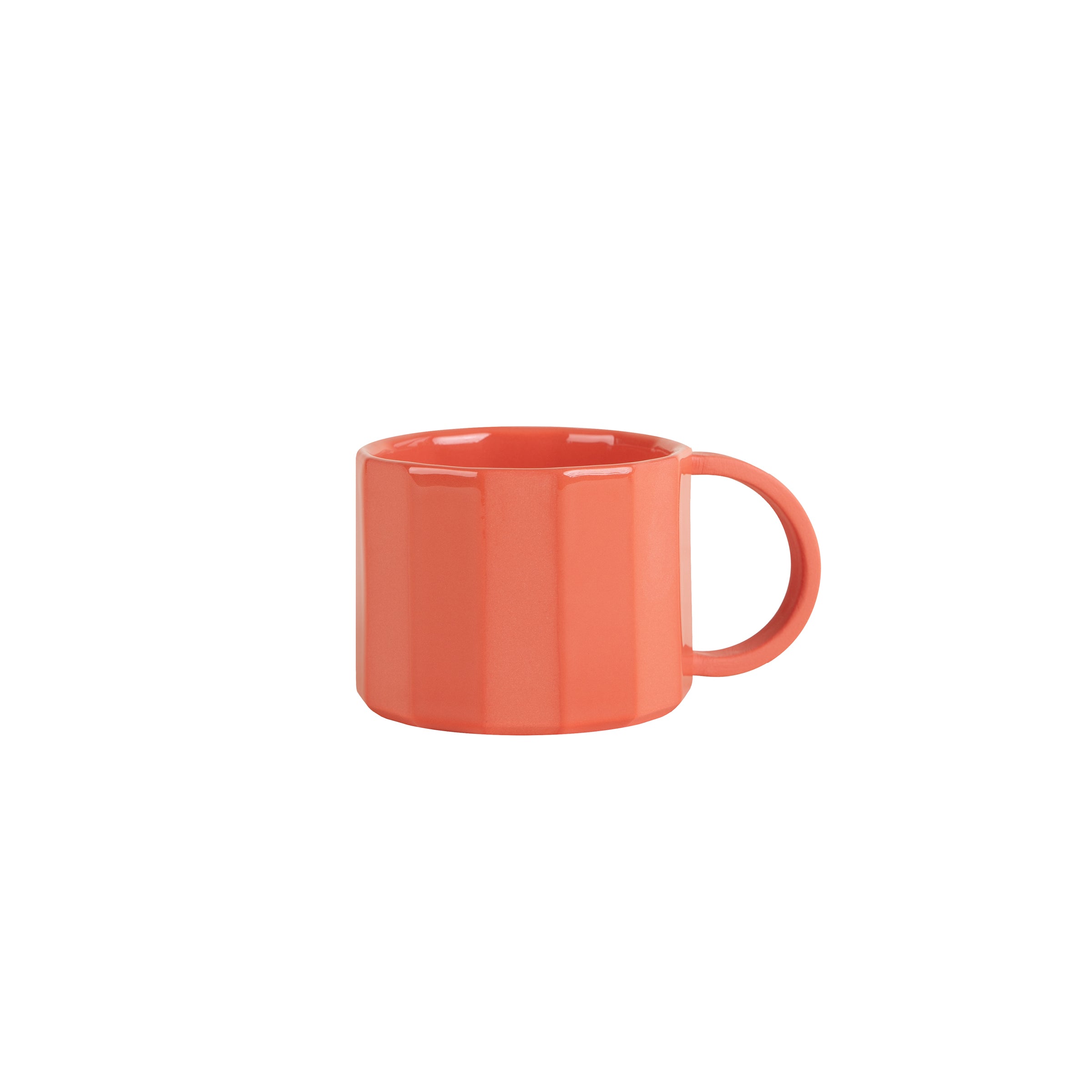 The Facet Tableware - Mug by Schneid is a vibrant red-orange ceramic piece with a wide handle and subtle vertical ridges, offering dynamic color contrast against its pristine white background.