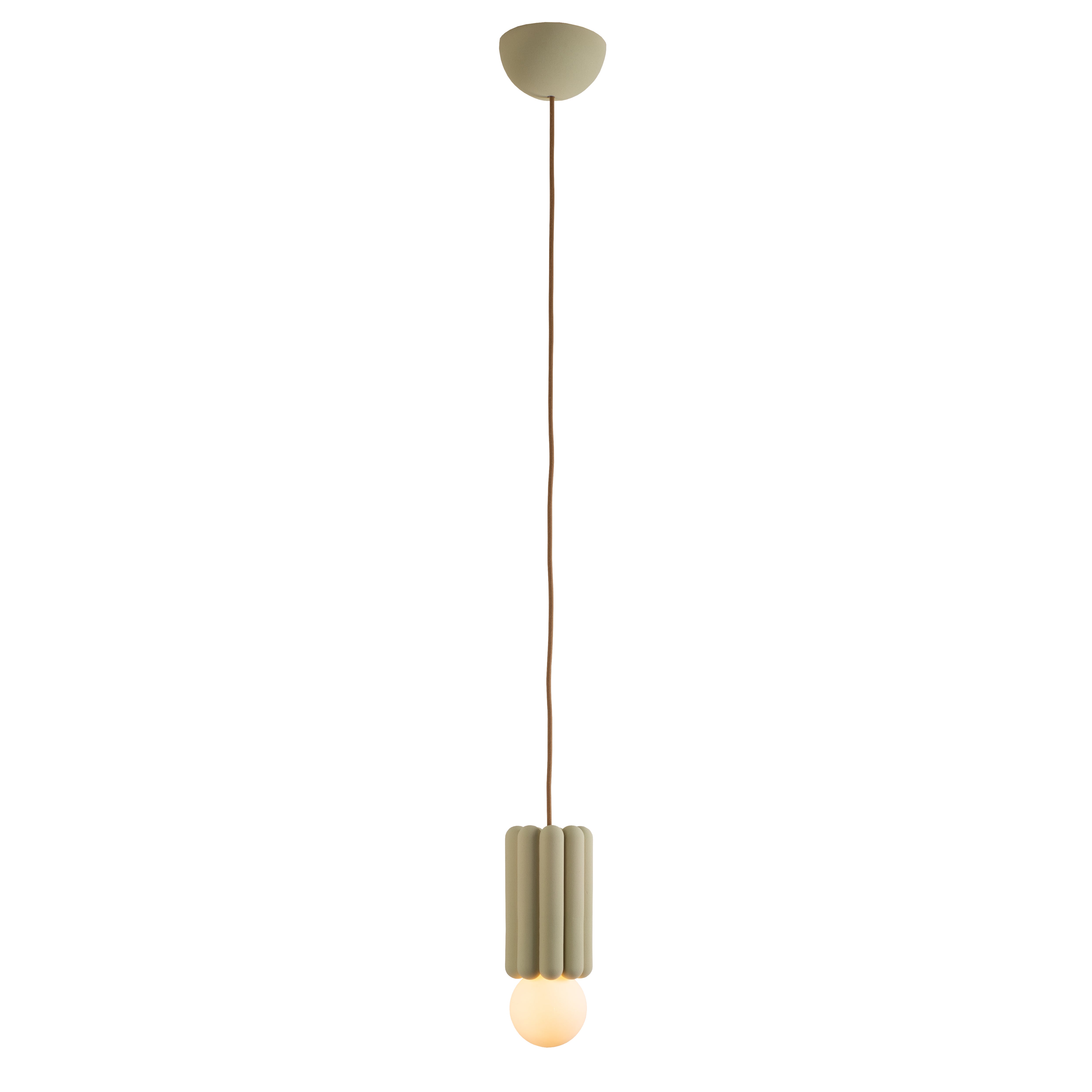 The Stucco No. III by Schneid is a hanging pendant light featuring a scalloped green fixture and a brown cord, showcasing creative luminosity with a round glowing bulb visible at the bottom.