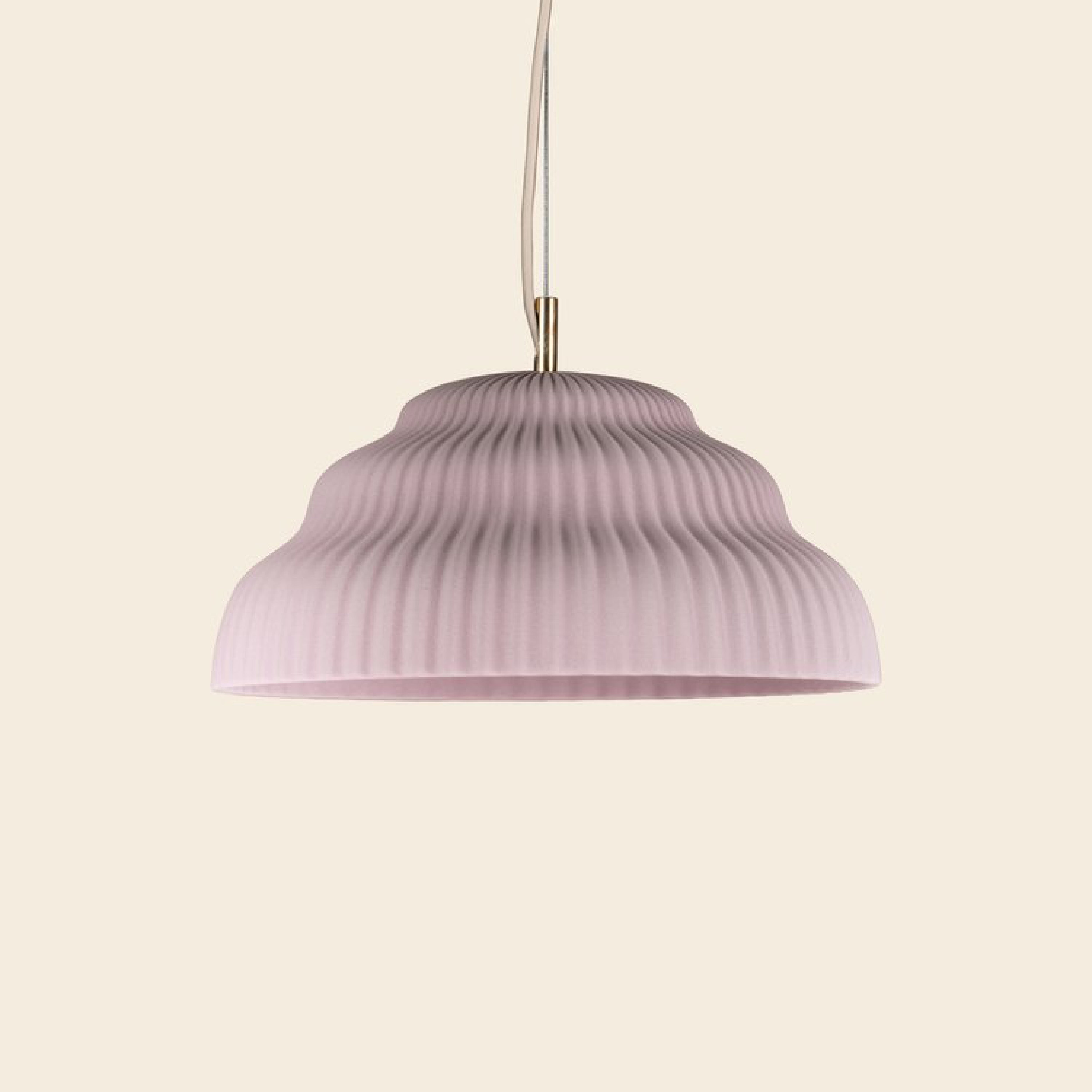 The Schneid Kaskad Cloud Pink lamp features a ribbed, dome-shaped design that hangs elegantly from a matching textile cable against a light beige background.