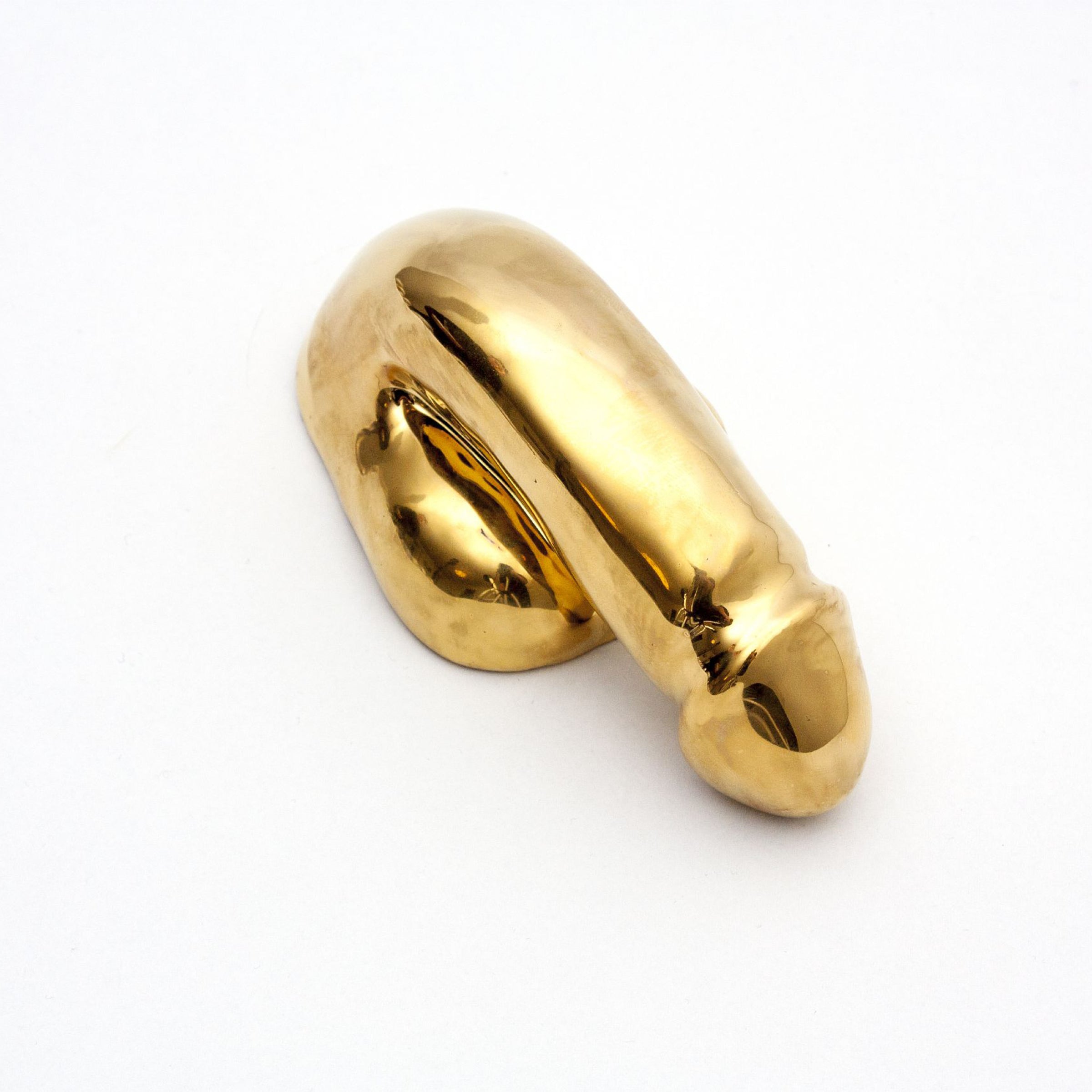 A Decorative Sex - Gold by Schwanzmanufaktur shines like a bent faucet with its reflective surface, set against a white background. This masterpiece could be the centerpiece for any art enthusiasts collection, embodying Oscar Wildes idea of recognizing beauty on bare canvas.