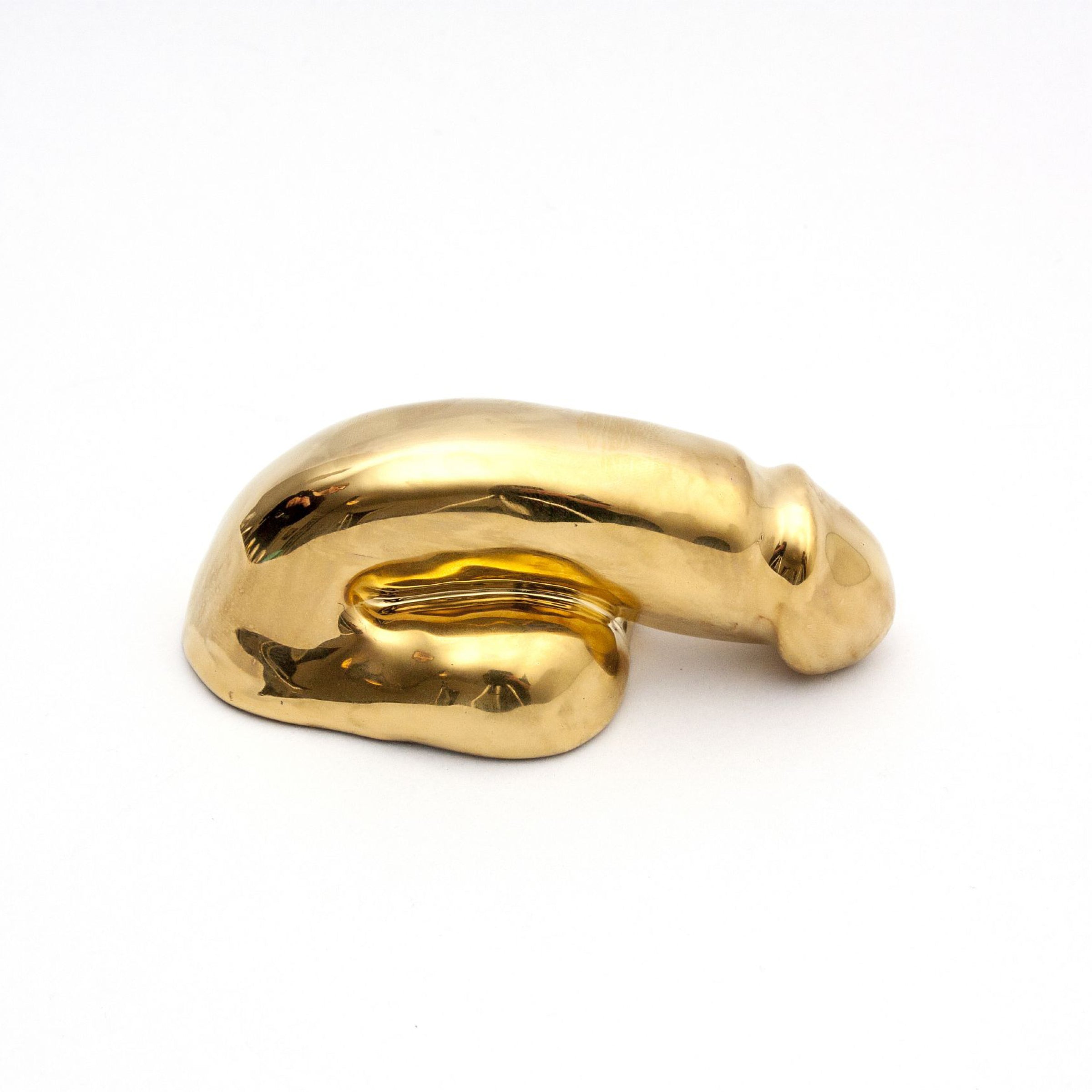 The A Decorative Sex - Gold by Schwanzmanufaktur is a smooth, abstract sculpture with organic, curved shapes that evoke Oscar Wildes essence. Set against a plain white background, its minimalist form invites contemplation and whispers elegance in simplicity.