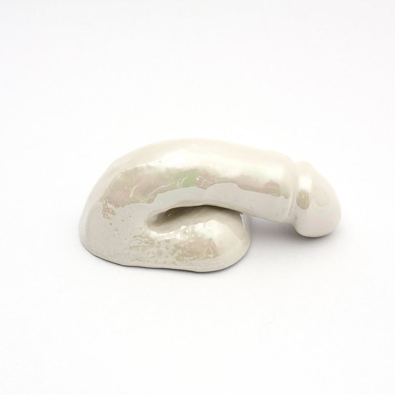 The A Decorative Sex - Pearl by Schwanzmanufaktur is a small, abstract white ceramic sculpture featuring a reclining figure. This piece showcases Austrian craftsmanship with its smooth, reflective surface, expertly designed to enhance any setting.