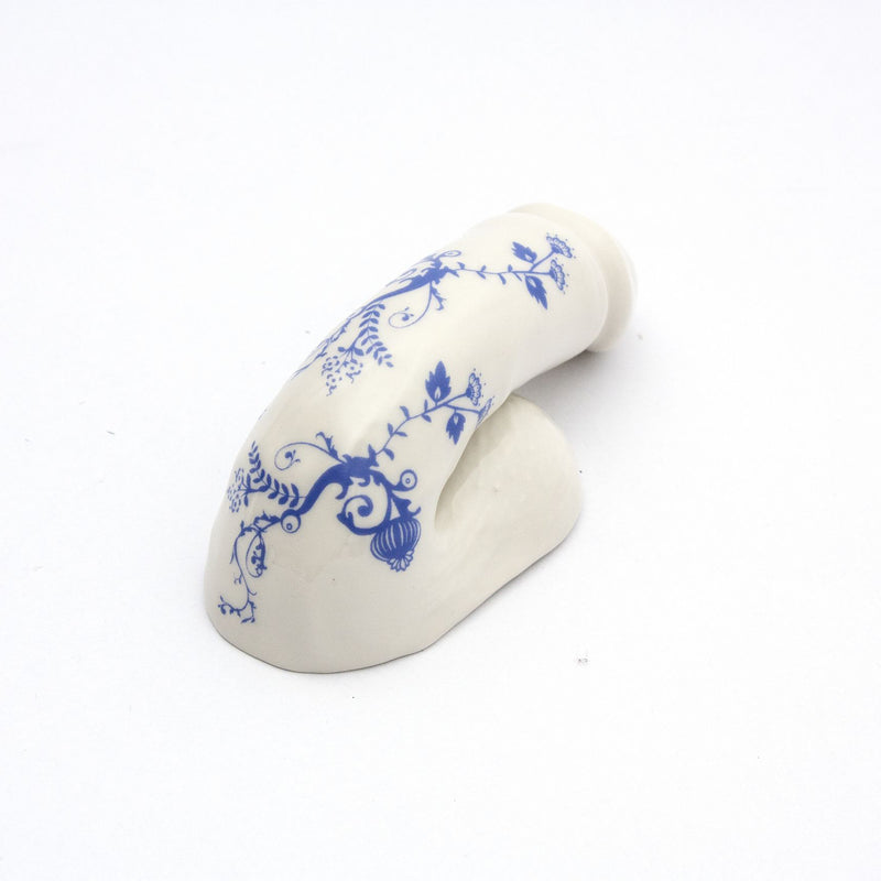 Handmade in Austria by Schwanzmanufaktur, the A Decorative Sex - Blue Onion 3 is a porcelain piece gracefully curved with intricate blue floral designs on a pristine white background, featuring a glossy finish and resembling the delicate artistry Oscar Wilde might have admired.