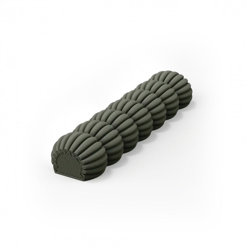 The Zayl 30g Mezuzah by Sheyn is a cylindrical foam roller with an eco-friendly composition, featuring a distinct segmented design with rounded ridges in dark green against a white backdrop.