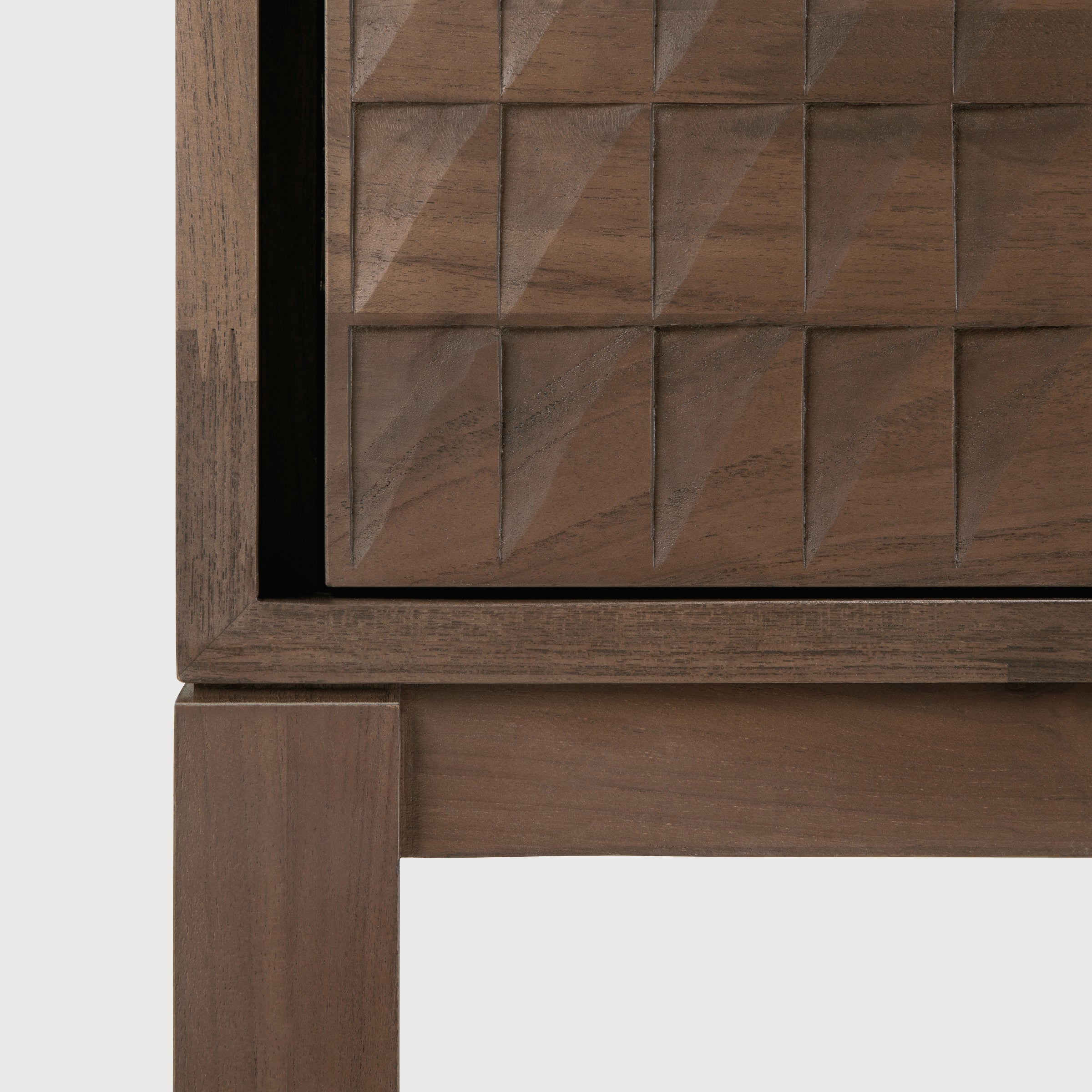 Close-up of hand-carved teak wood panel detail on the Sono Cupboard with elegant brass handle accents.
