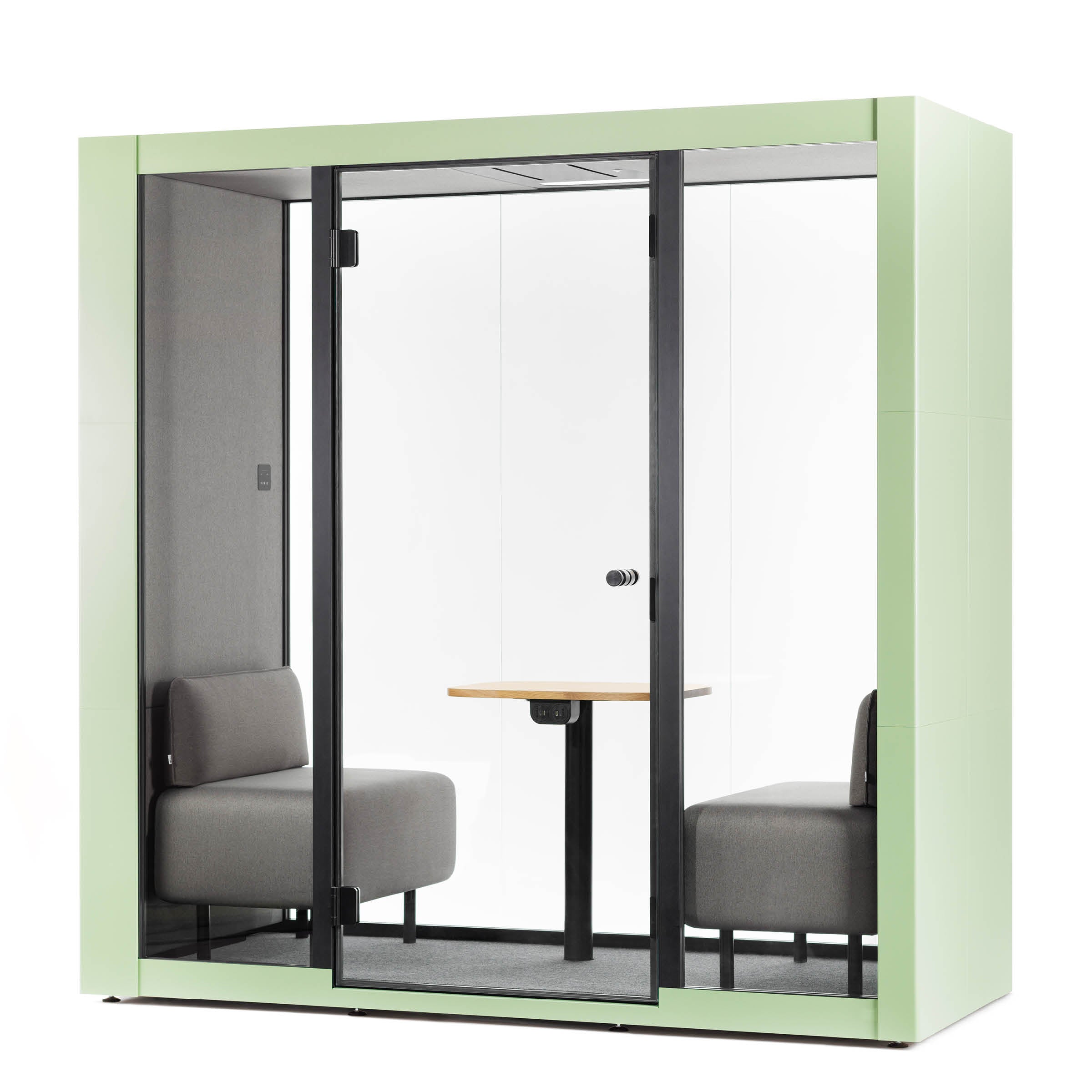 The OFFICE POD SPARK 2 by SilentLab features a light green exterior, glass door, and walls. Inside are two gray cushioned seats facing each other with a small wooden table in between. Its compact, minimalistic design offers excellent working conditions by effectively minimizing ambient sounds.