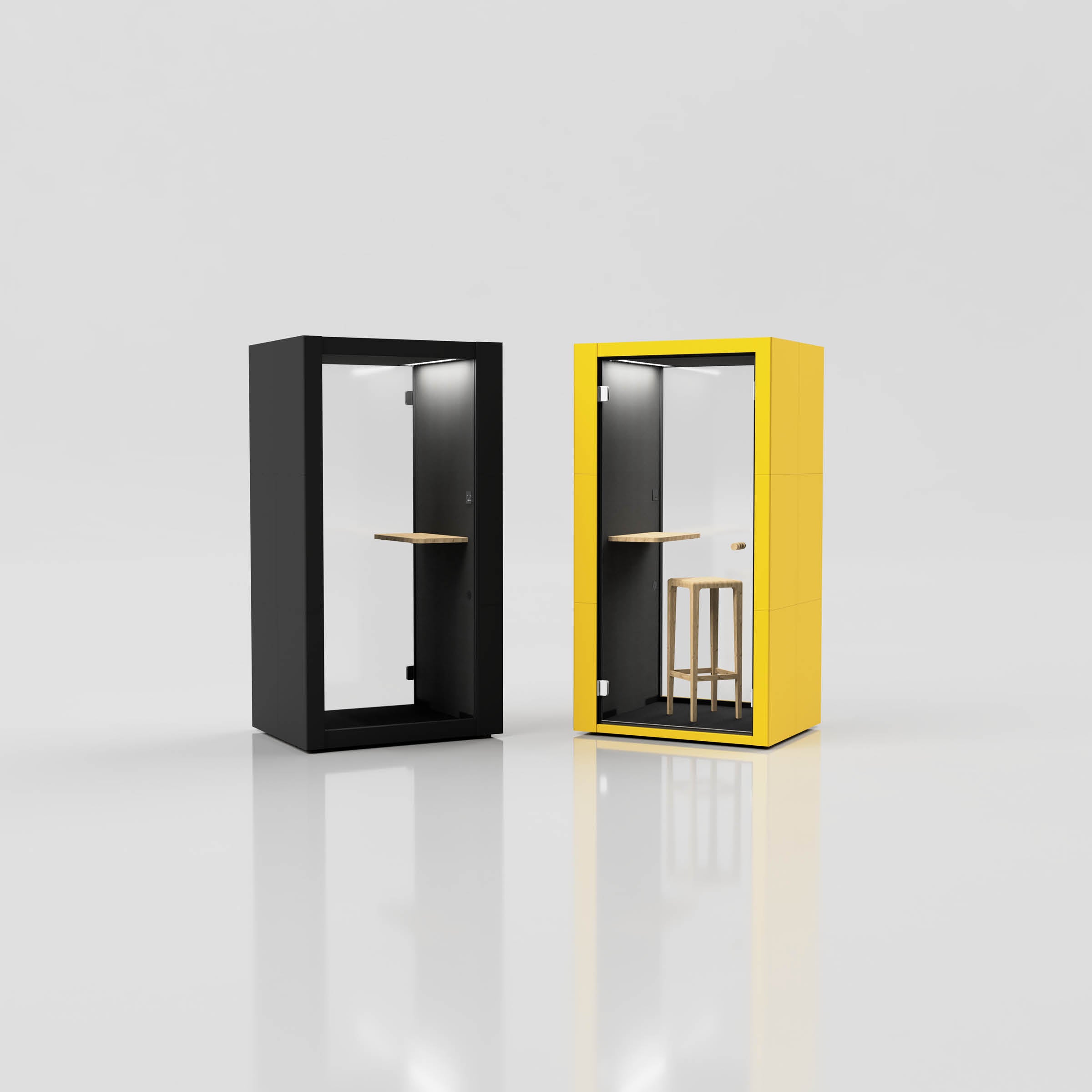 Two SilentLab OFFICE POD SPARK booths sit side by side on a glossy floor. The left is black, the right is yellow. Resembling acoustic office pods, each features a small wooden shelf and a transparent door. A wooden stool adorns the yellow booth, combining style with functionality.