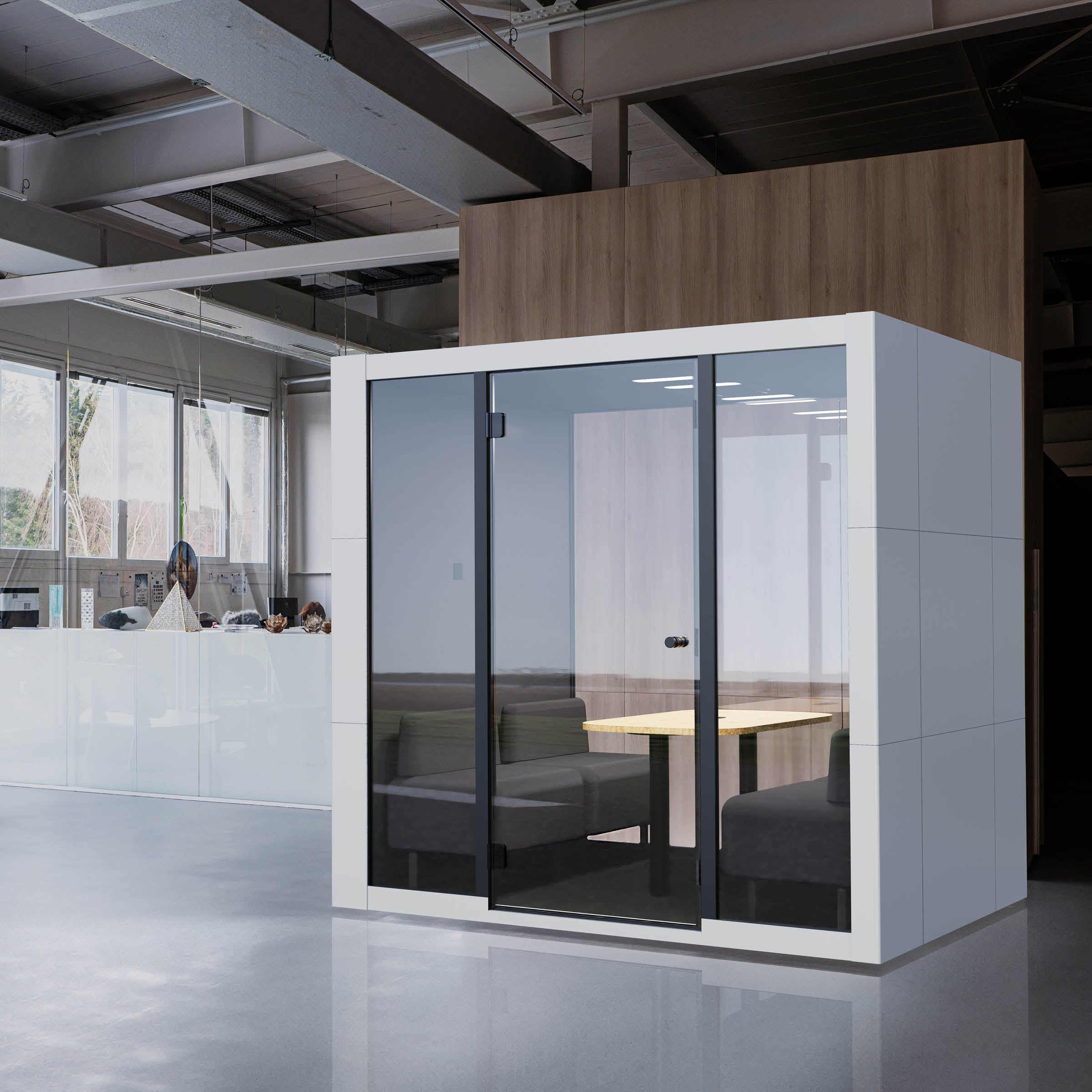 A modern office includes a glass-enclosed OFFICE POD SPARK 4 by SilentLab, boasting a wooden interior with a small table and cushioned seating. Ideal for private meetings, this pod is located before a larger open area with desks and windows.
