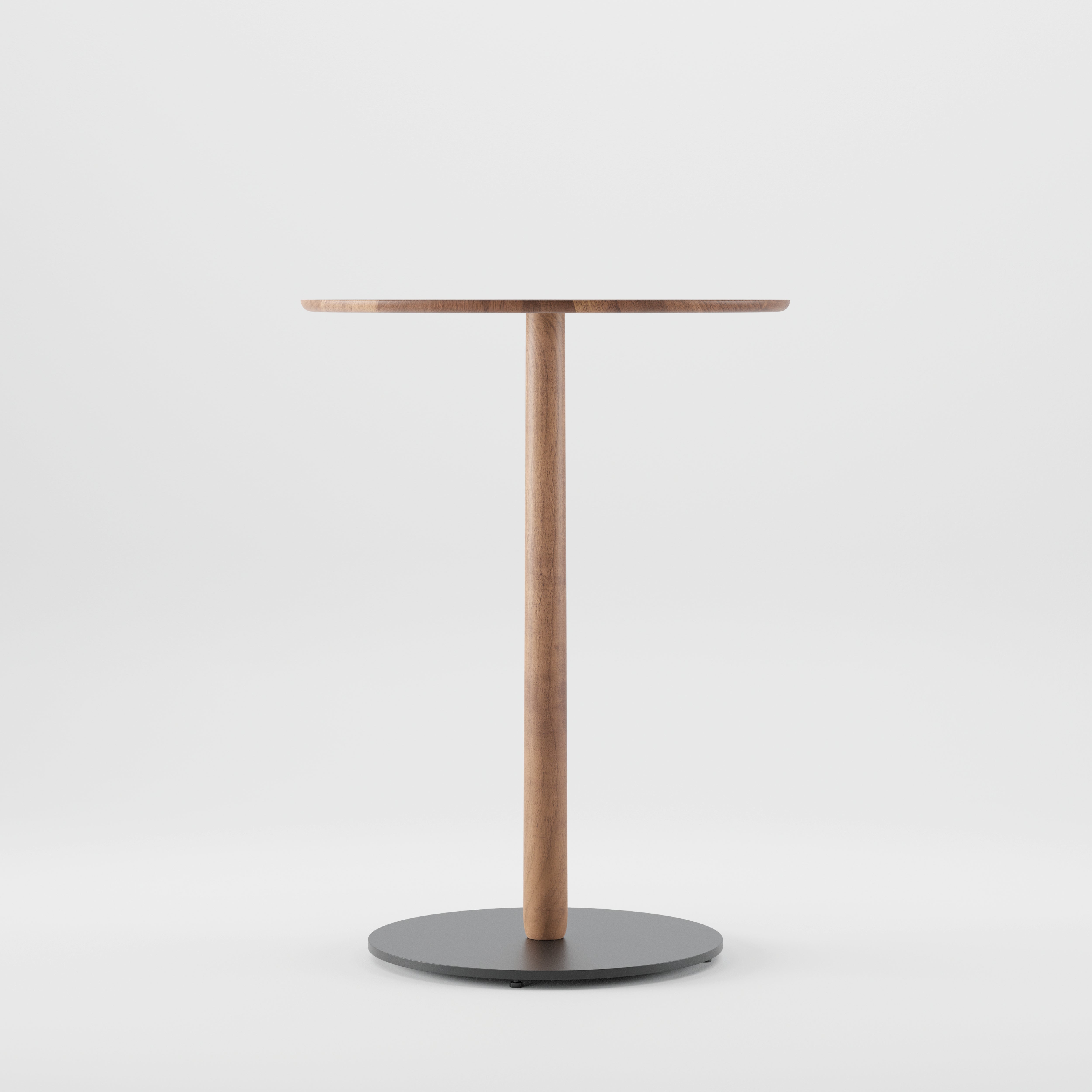 The Artisan Bistro B Table features a minimalist design with a smooth circular solid wood top and a central leg on a round black base, crafted from environmentally-friendly materials, offering simple elegance against a plain white background.