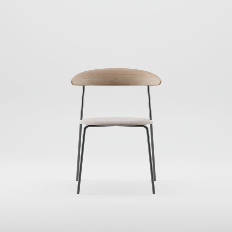 The KINU Chair by Artisan features a minimalist design with a light wooden backrest treated with natural oils, a fabric-covered seat, and slender black metal legs, all set against a plain white background.