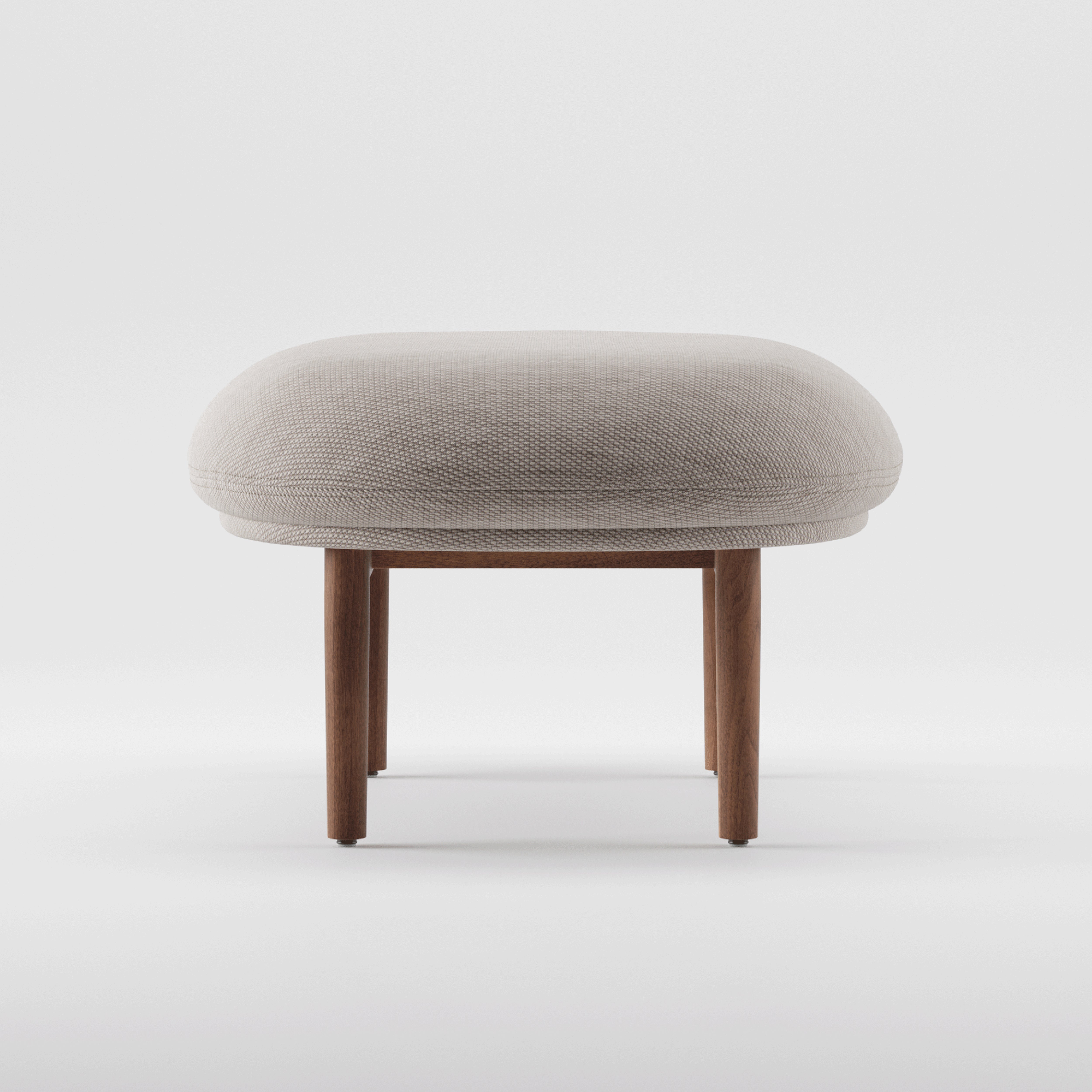 Introducing the Artisan MELA Ottoman: a minimalist piece with a round, cushioned gray seat and sturdy wooden legs. Positioned against a plain white background, it showcases its simple, modern design; featuring an elegant upholstered shell.