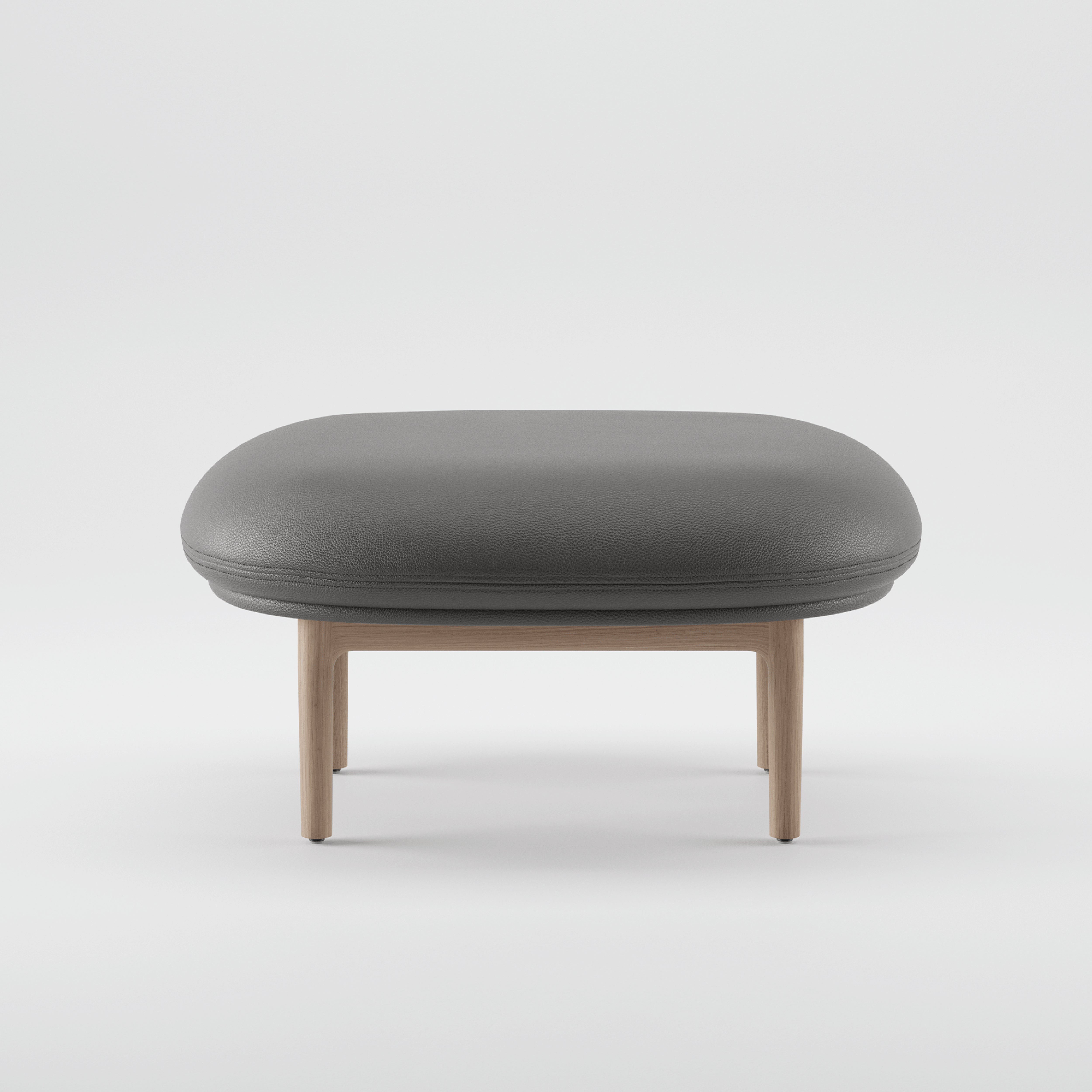 A modern MELA Ottoman from Artisan, featuring a minimalist design with a rounded upholstered gray top and sturdy wooden structure, is centered against a plain white background.