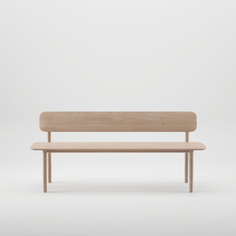 The Artisan NEVA Bench with backrest showcases a minimalist wooden design, featuring a light finish and crafted from natural wood. It stands against a plain white background, highlighting its clean, modern aesthetic with four legs and a simple backrest.