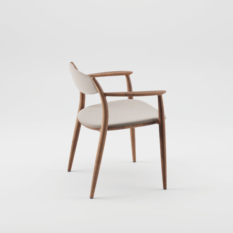 The Artisan NILA Chair is an elegant mid-century modern piece featuring a curved wooden frame crafted from solid wood, complemented by a beige cushioned seat and backrest, set against a plain white background.