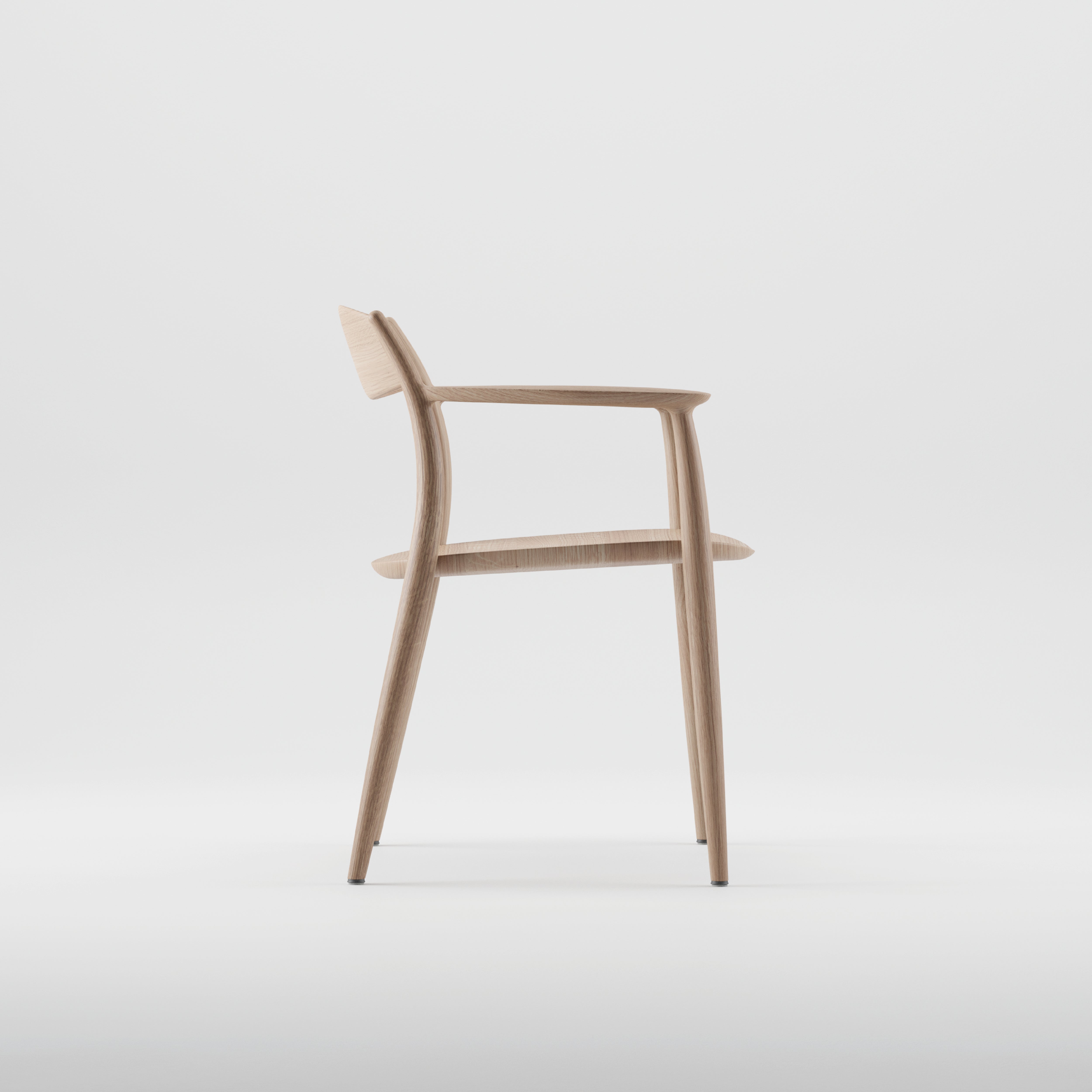 The NILA Chair by Artisan is a minimalist wooden chair with a sleek design, featuring a curved backrest and armrests. Crafted from solid wood with natural oils, it embodies eco-friendly elegance, showcasing its modern sophistication against a plain white background.