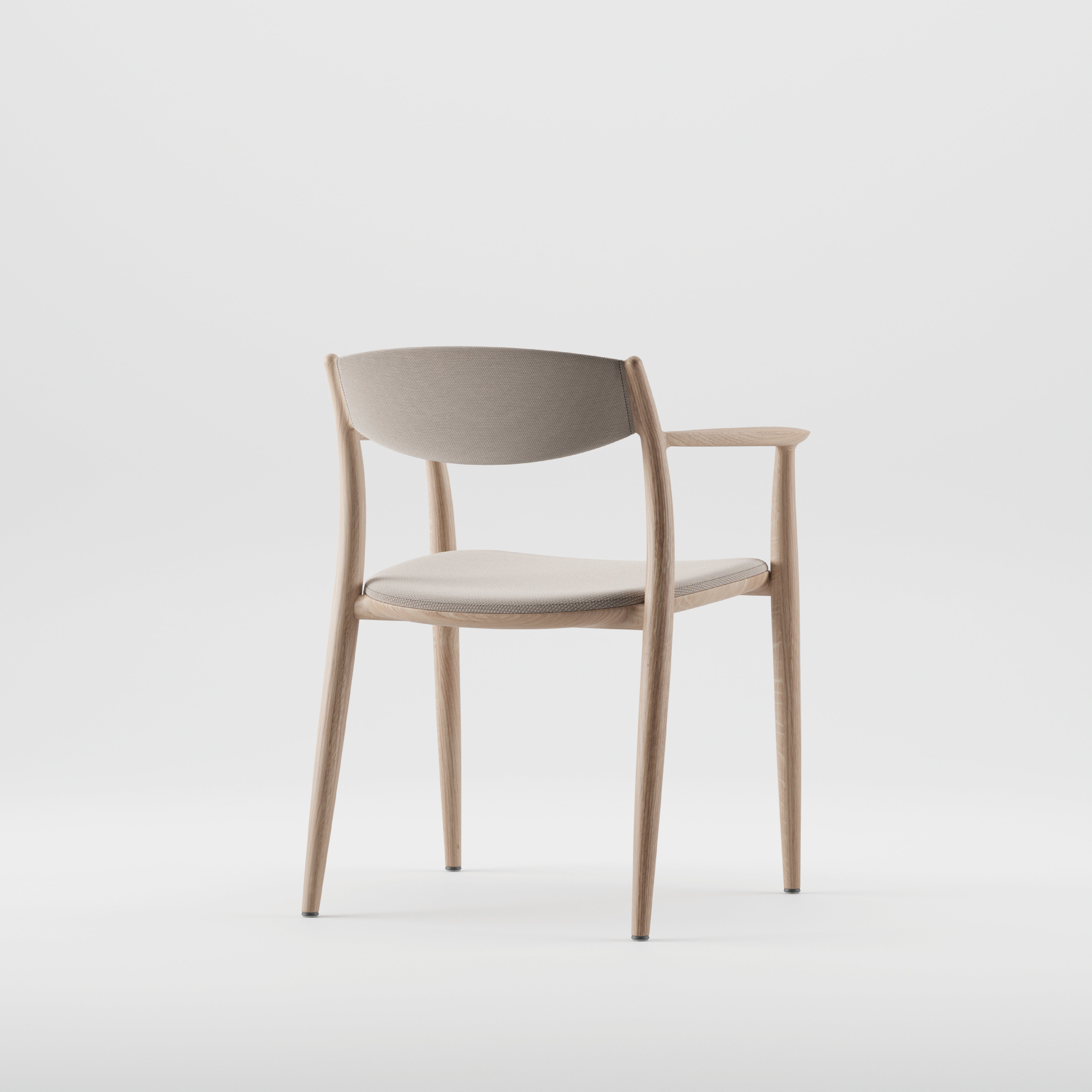 The NILA Chair by Artisan, seen from the side against a white background, is crafted from solid wood with a curved backrest and padded seat. It features light natural wood tones and beige upholstery made from environmentally-friendly materials.