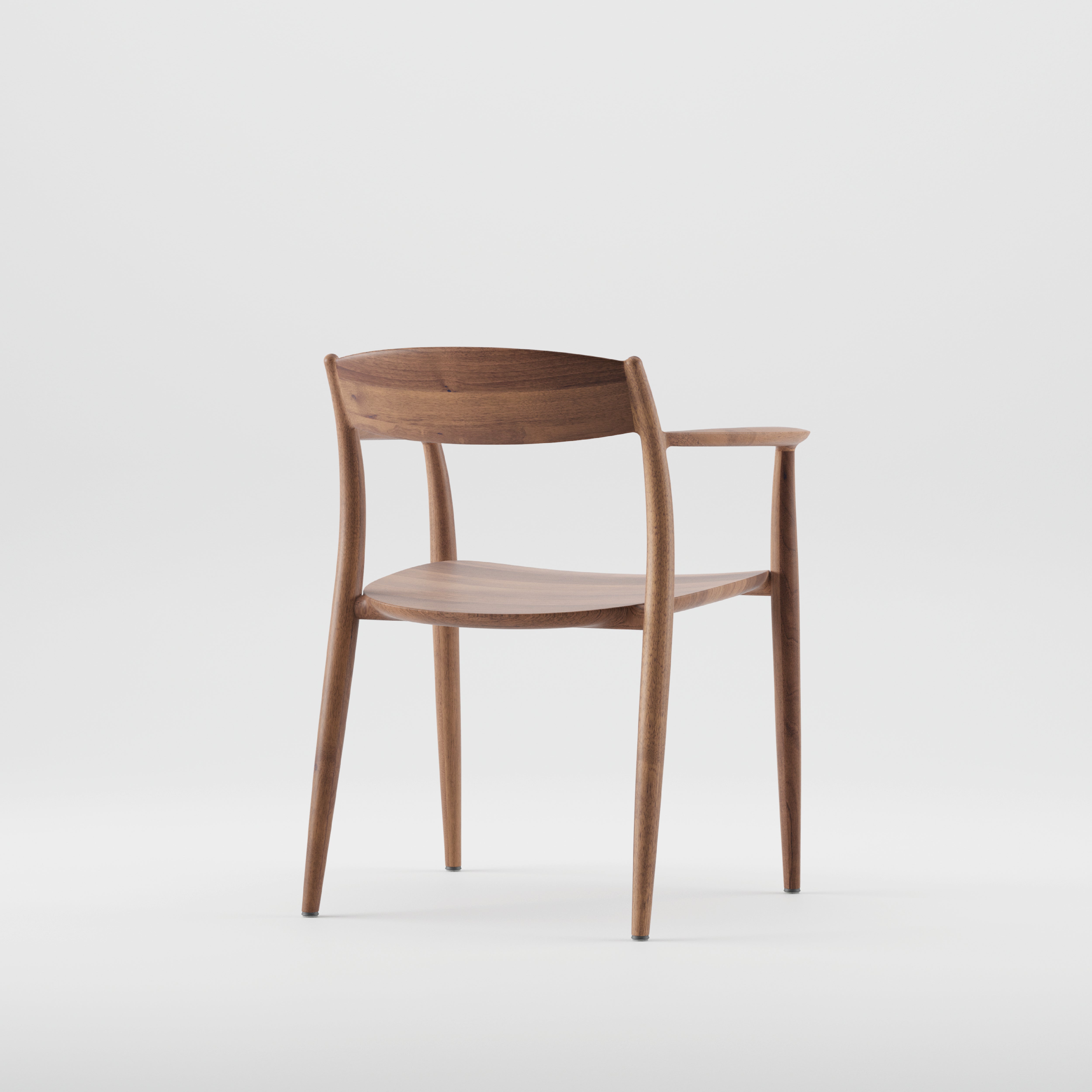 The NILA Chair by Artisan is a minimalist wooden chair crafted from solid wood. It features smooth, curved lines, a natural finish, a rounded backrest, angled legs, and sleek armrests enhanced by natural oils for added luster against a plain white background.