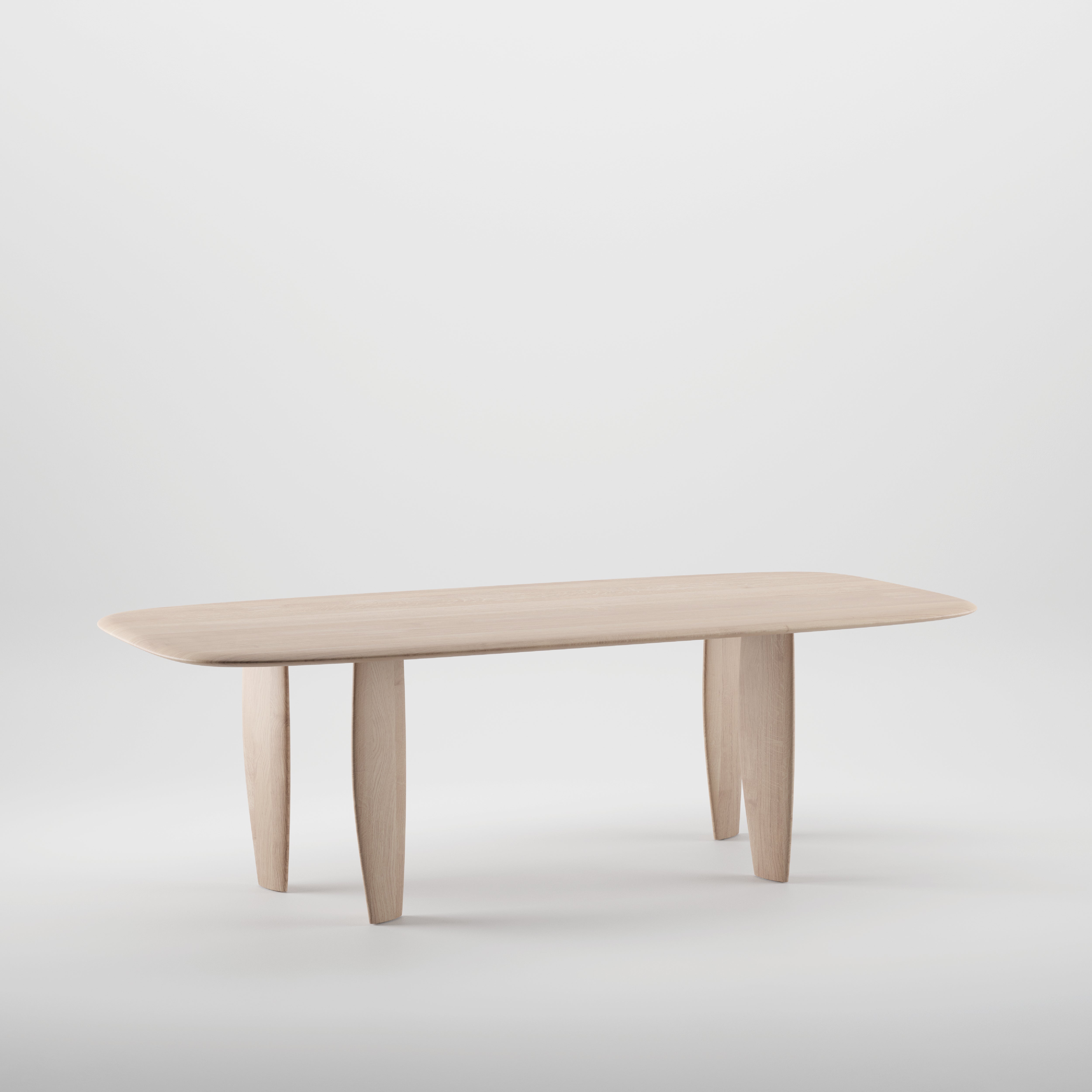 The Artisan NILU Table is a minimalist, light wood piece crafted from solid wood with rounded edges and four tapered legs. Enhanced with natural oils, it exudes a sleek, modern design on a plain, light background.