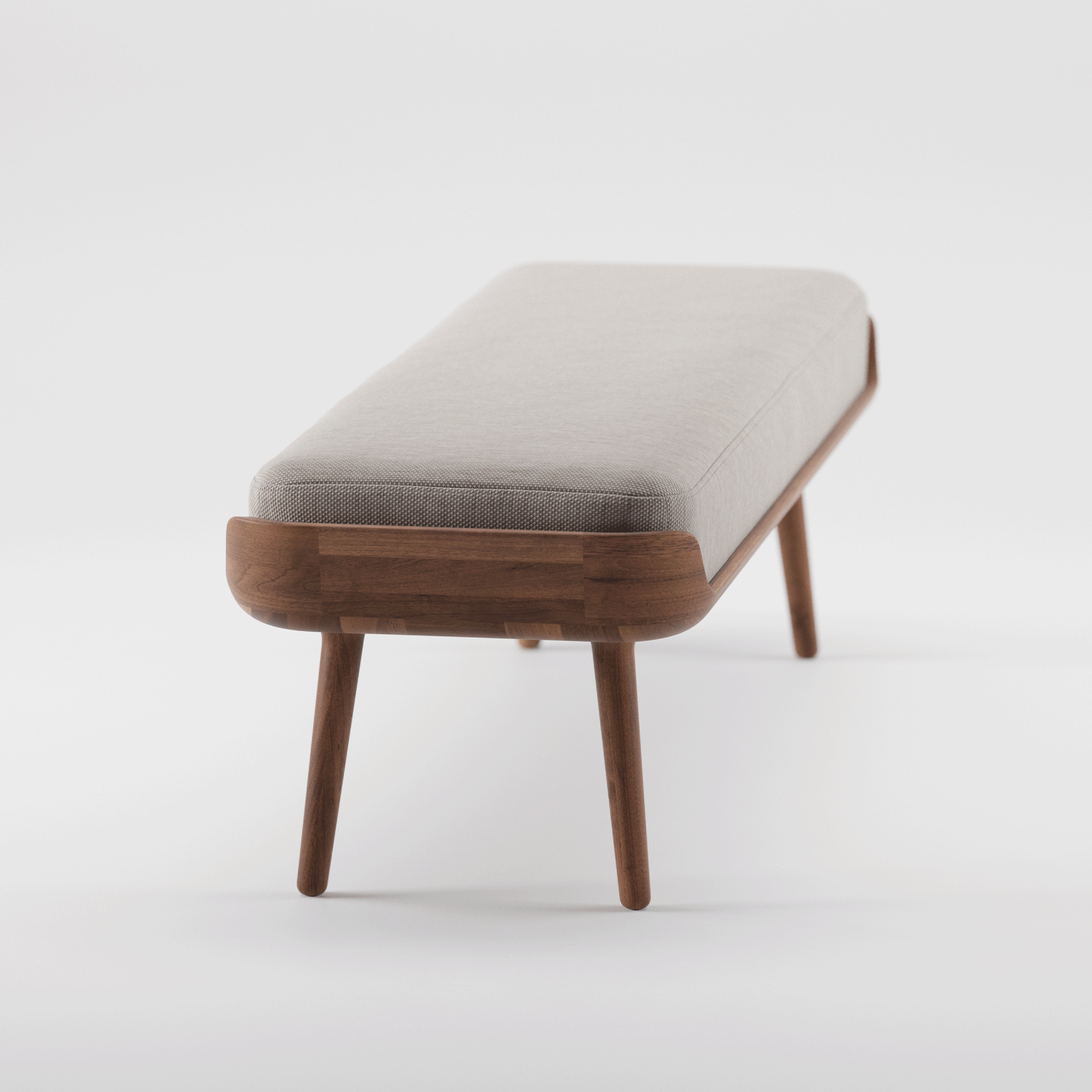 The THOR Bench by Artisan features a minimalist design with solid wood construction and a natural texture. It has four tapered legs and a light gray rectangular cushion with rounded corners, set against a white background.